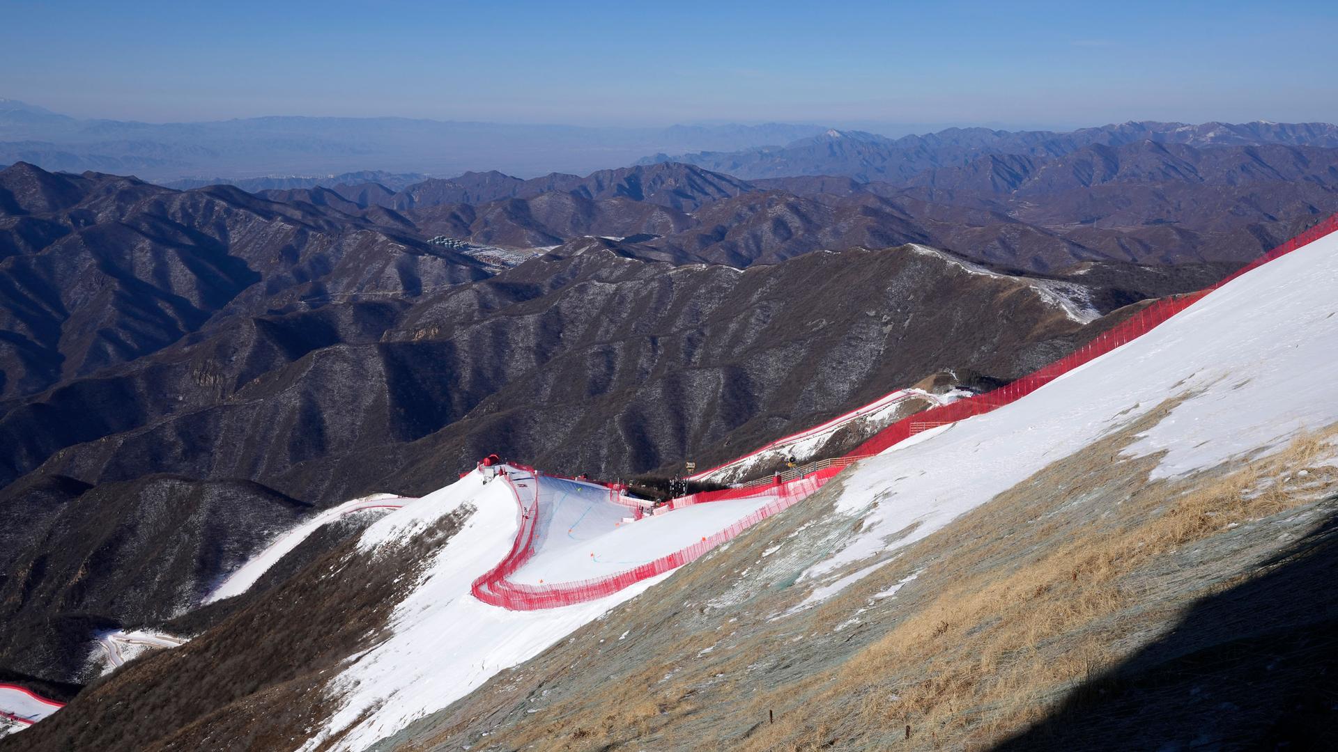 The downhill course stands out from the almost snowless landscape ahead of the first men's downhill training run at the 2022 Winter Olympics, Feb. 3, 2022, in the Yanqing district of Beijing. 