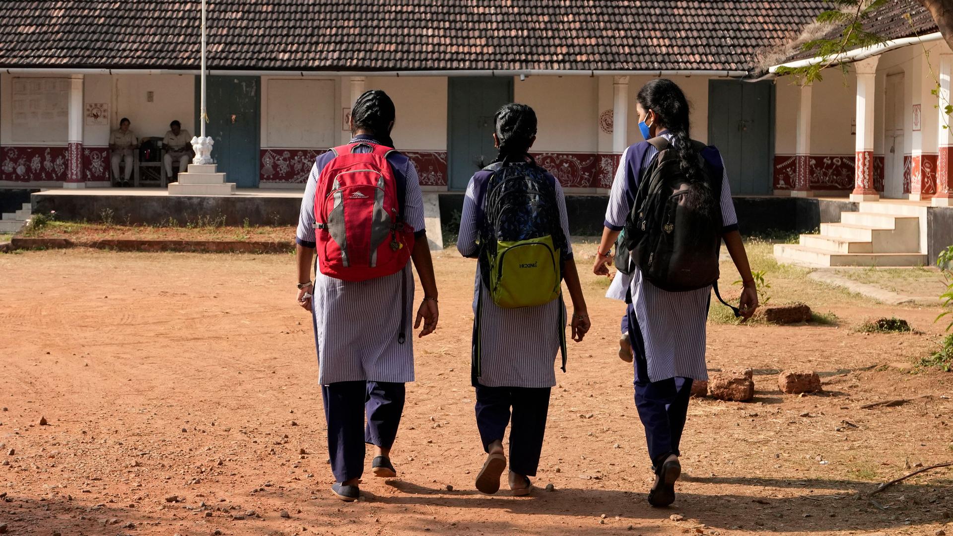 Indian students in uniform clothing arrive at a government-run junior school in Udupi, Karnataka state, India, Thursday, Feb. 24, 2022. 