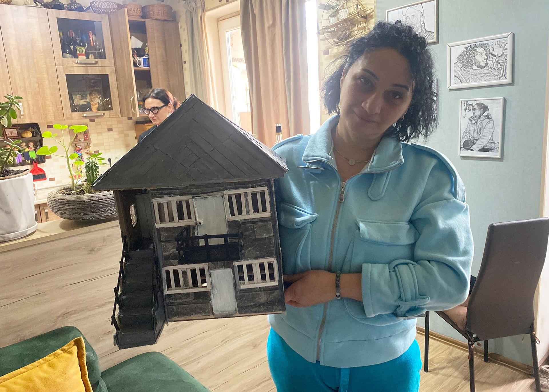 Irina Kotua stands with a model of the house where she used to live in Abkhazia before she fled the region in 1993, during a war between Georgia and Abkhaz separatists, who were backed by Russia.