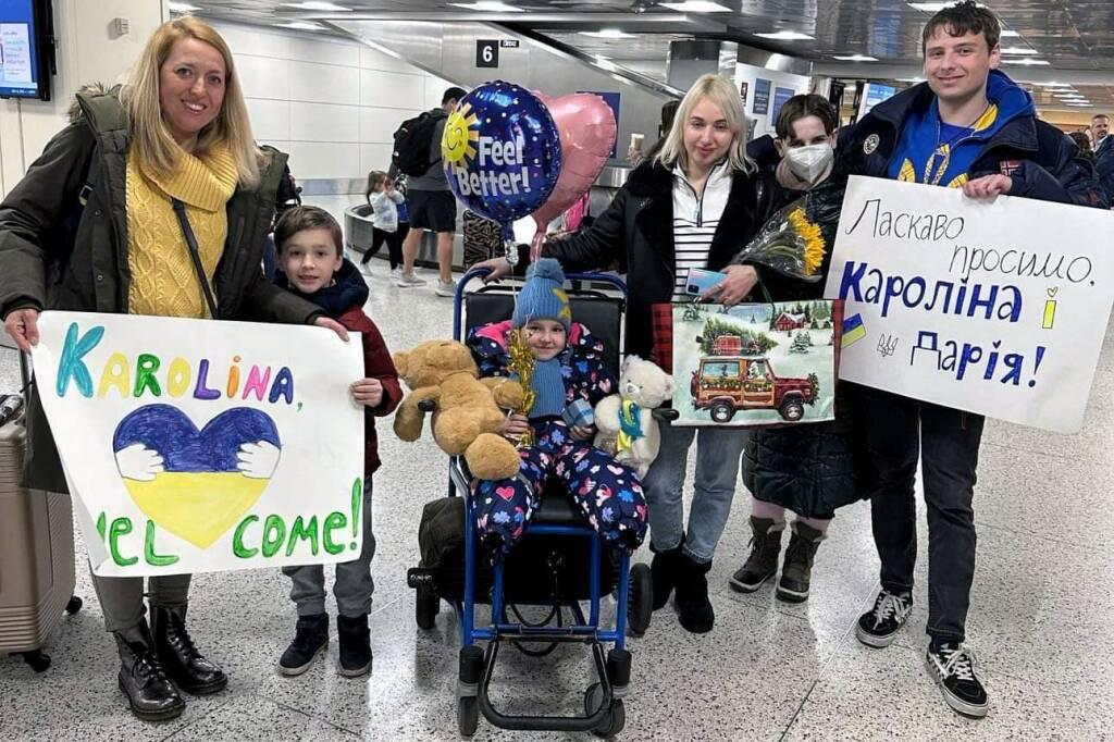 Volunteers welcome Karolina Daremyan and Daria Khatina (center and third from right) to Logan Airport in January 2023.
