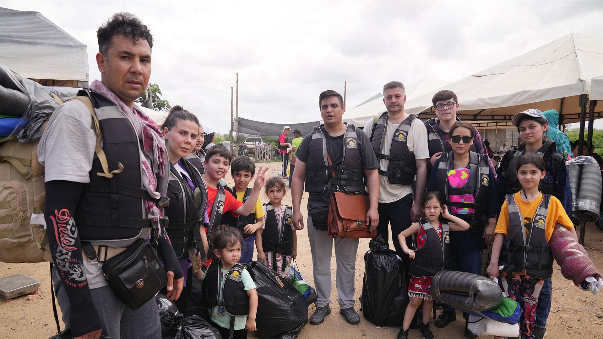 Three families from Afghanistan prepare to board a boat in Necocli, Colombia, that will take them towards the border with Panama.