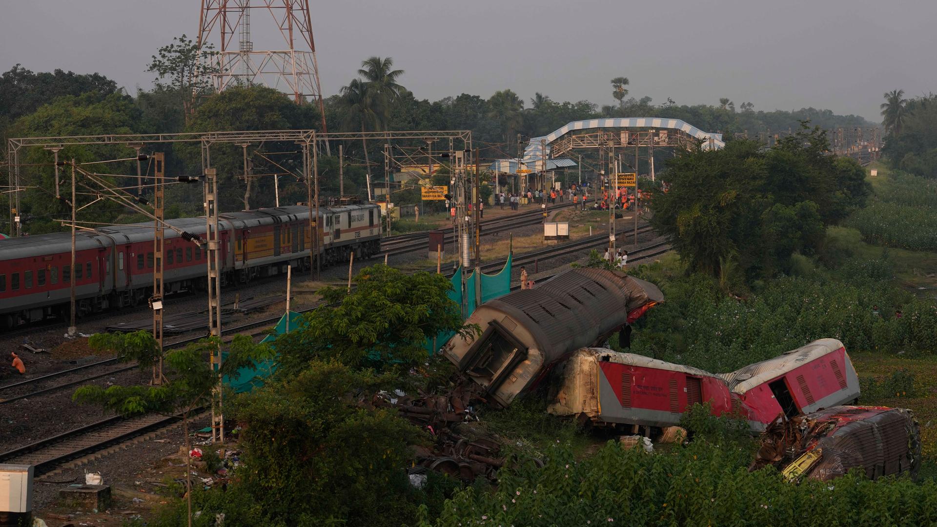 A passenger train passes by the site where two passenger trains derailed Friday in Balasore district, in the eastern Indian state of Odisha, Monday, June 5, 2023. 