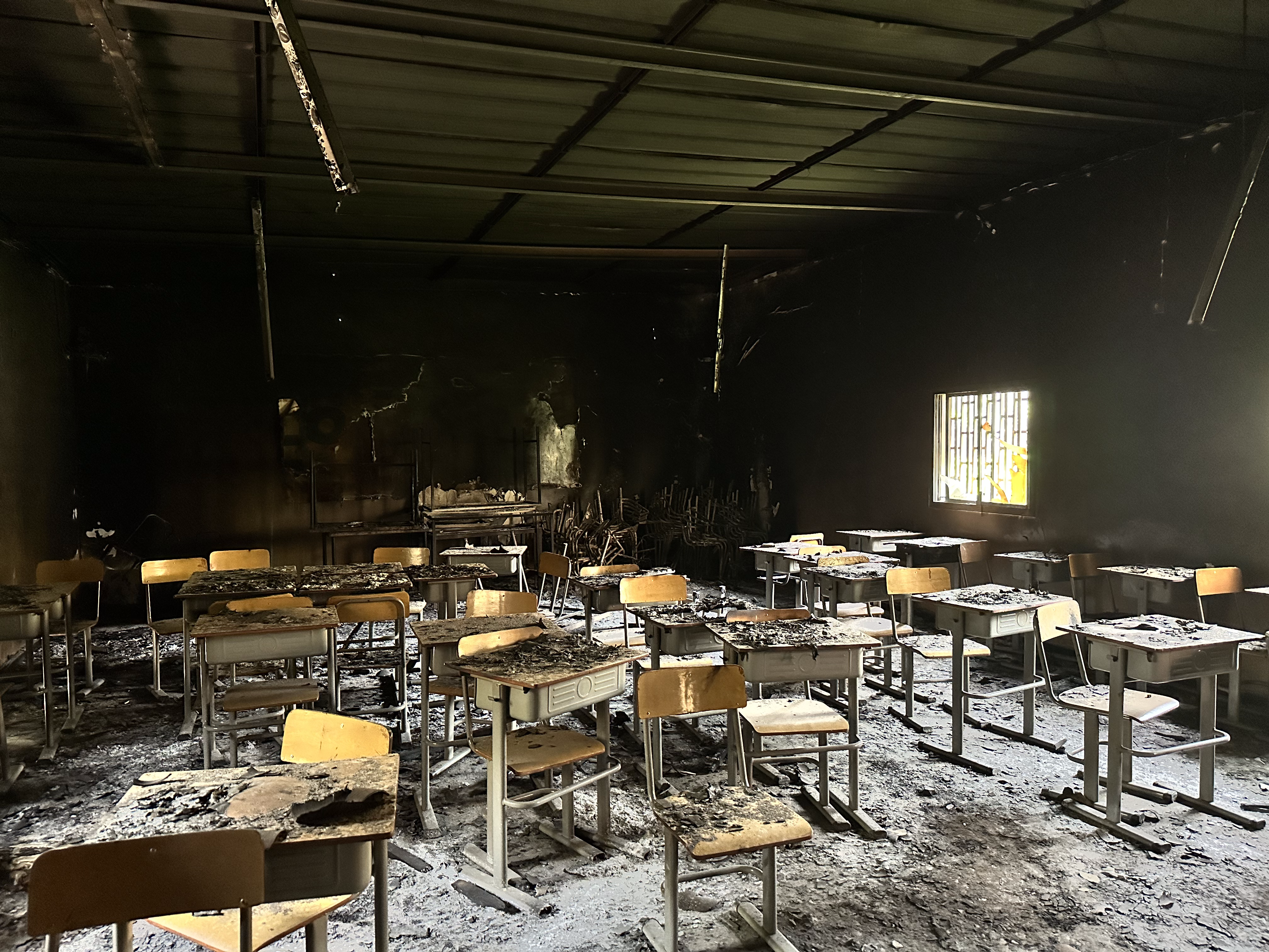 photo of a classroom with desks burned by fire