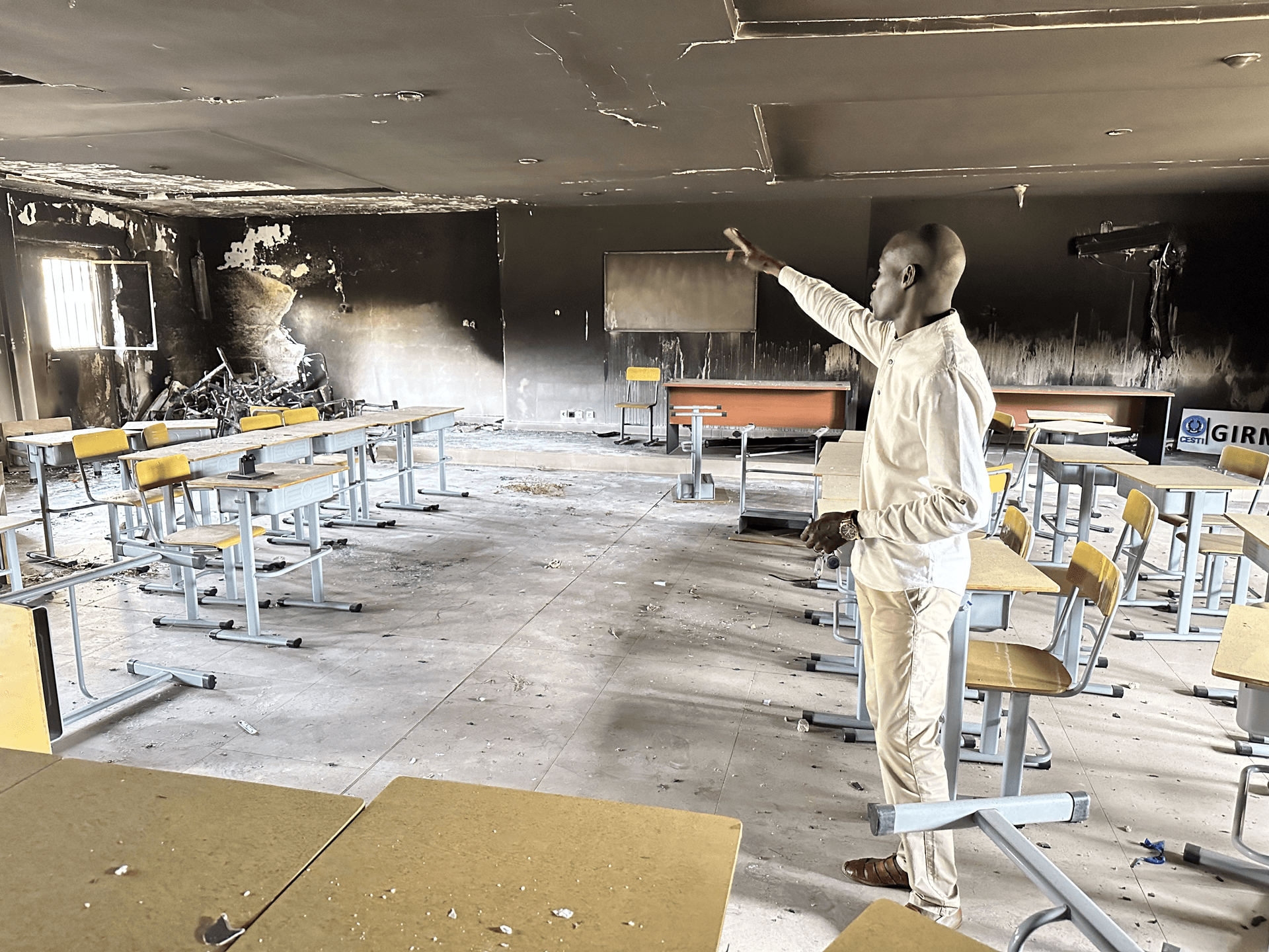 A man standing and showing a burned classroom
