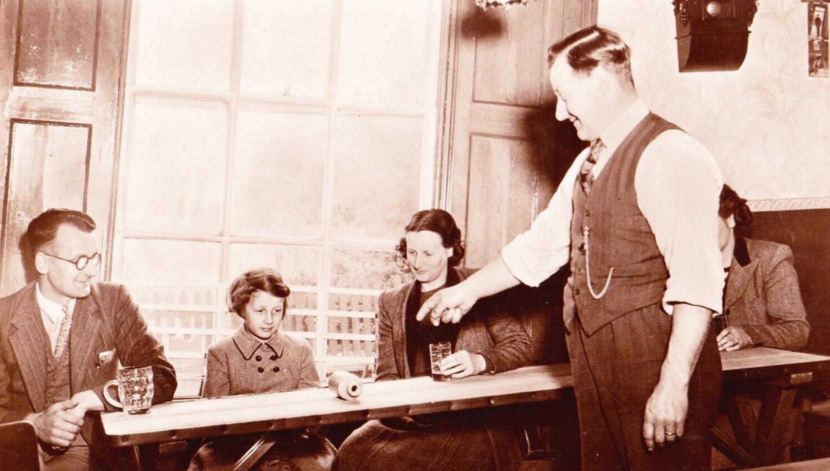 An old photo of the magic table where bottles rolled up-hill at The Crooked House pub.