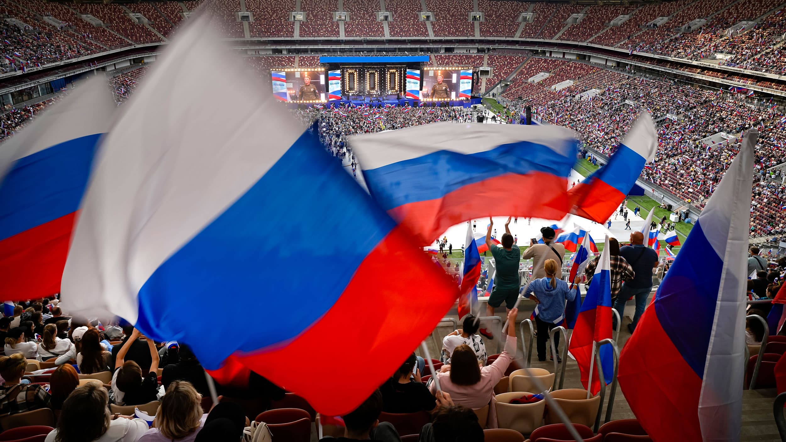 Participants wave Russian national flags during the concert at the Luzhniki Stadium to mark the Russia's National Flag Day, in Moscow, Russia, Tuesday, Aug. 22, 2023.