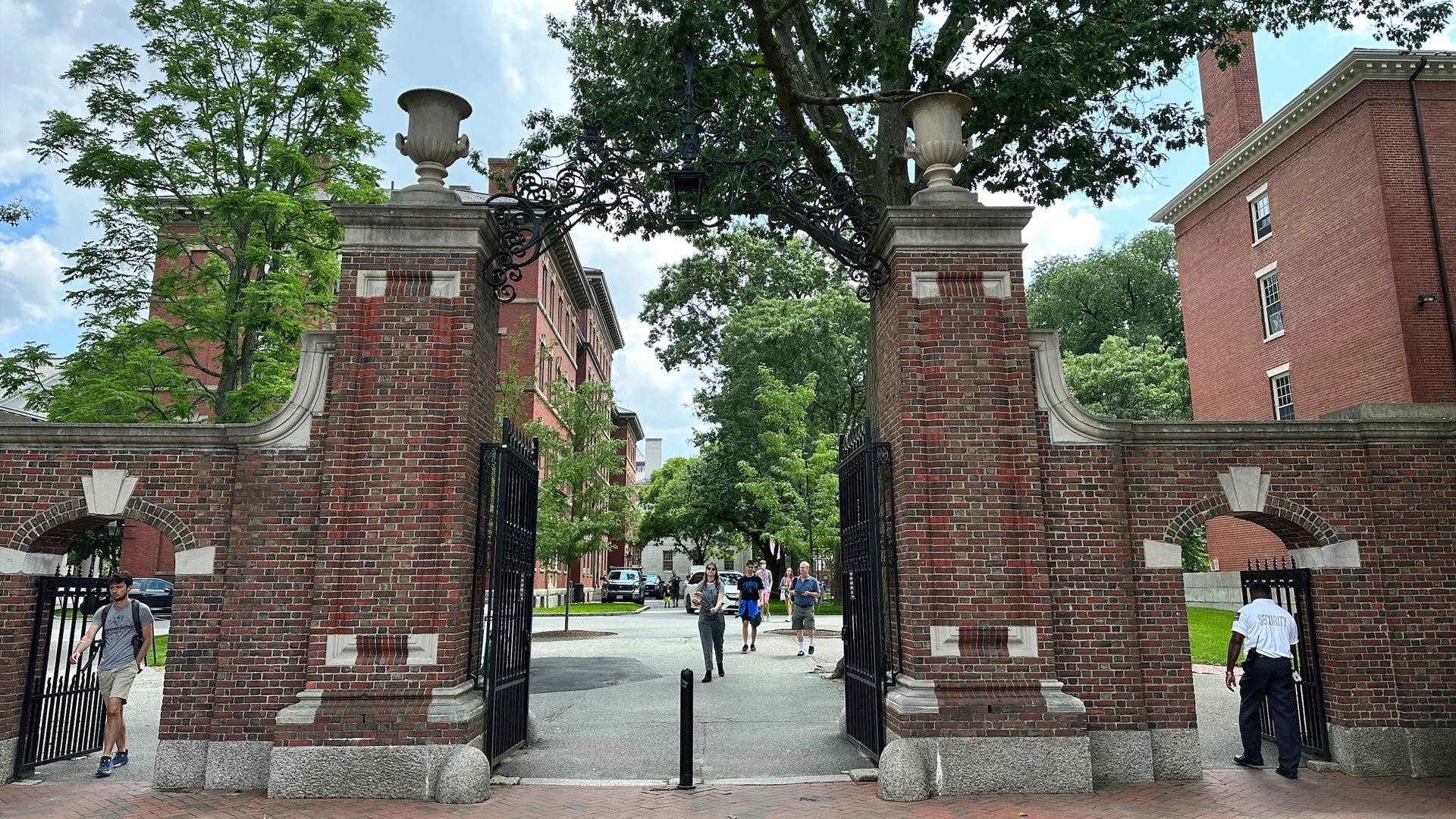 Students walk through a gate at Harvard University, Thursday, June 29, 2023, in Cambridge, Mass.