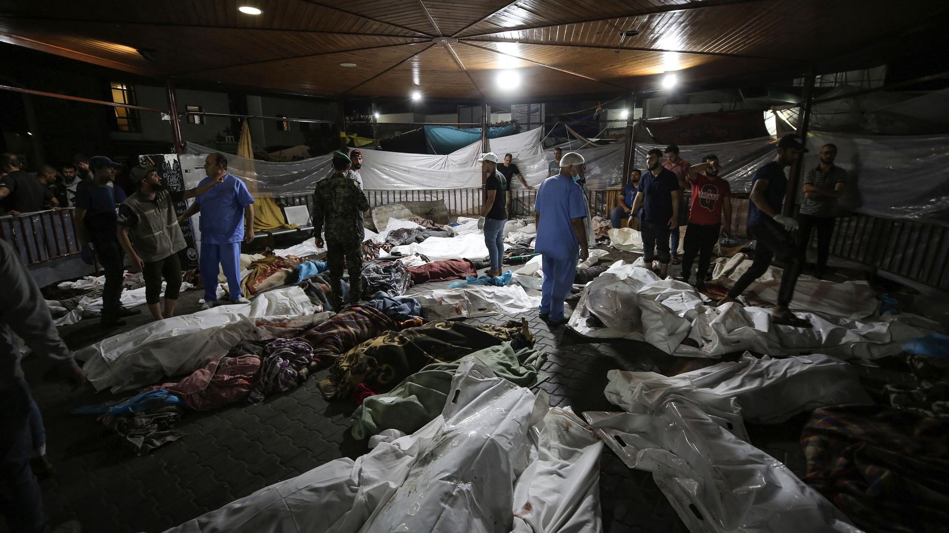 Bodies of Palestinians killed by an explosion at the Ahli Arab hospital are gathered in the front yard of the al-Shifa hospital, in Gaza City, central Gaza Strip, Tuesday, Oct. 17, 2023.