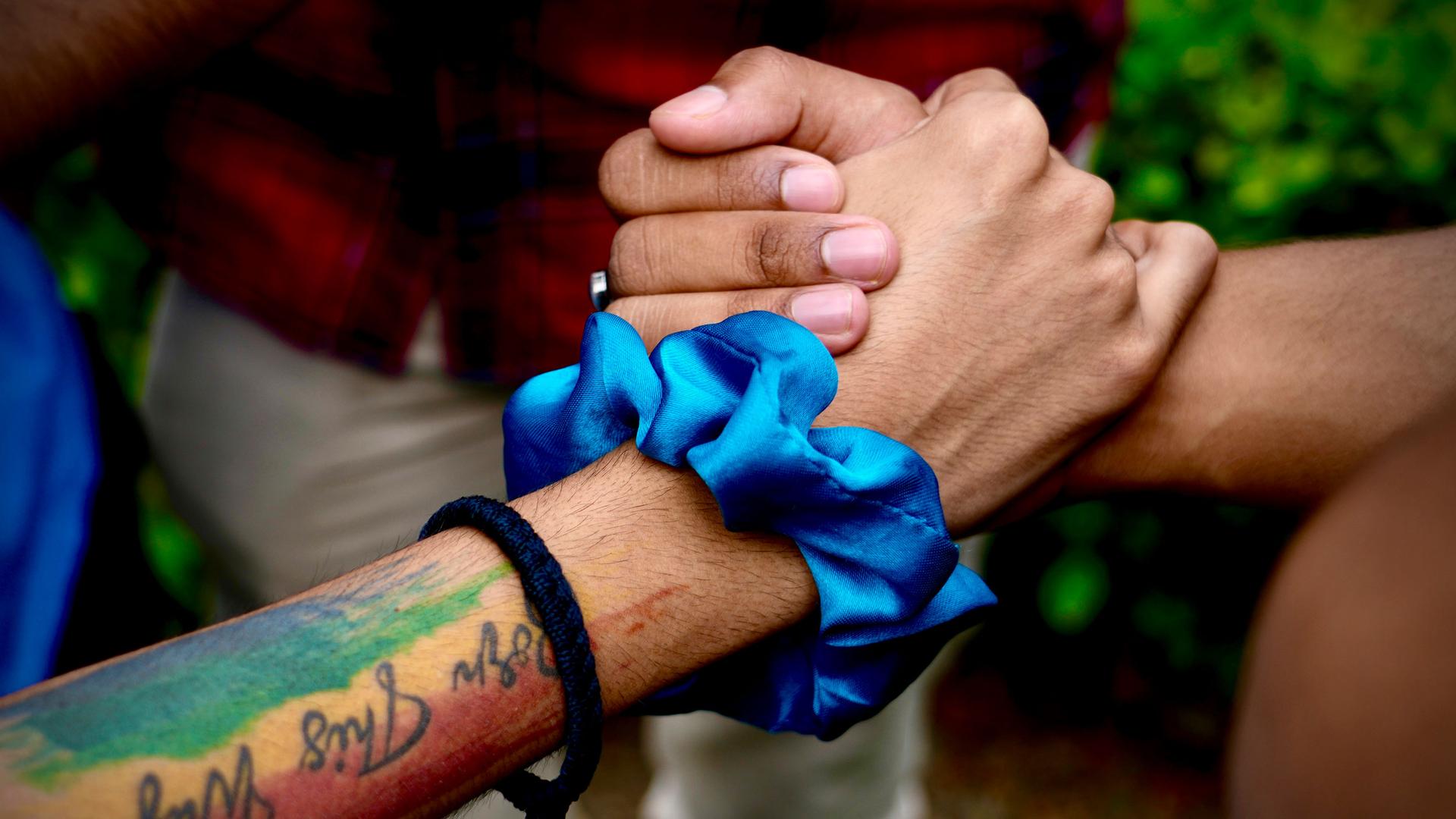 LGBTQ community supporters and members hold hands as they wait for the Supreme Court verdict on petitions that seek the legalization of same-sex marriage, in New Delhi, India, Tuesday, Oct. 17, 2023. 