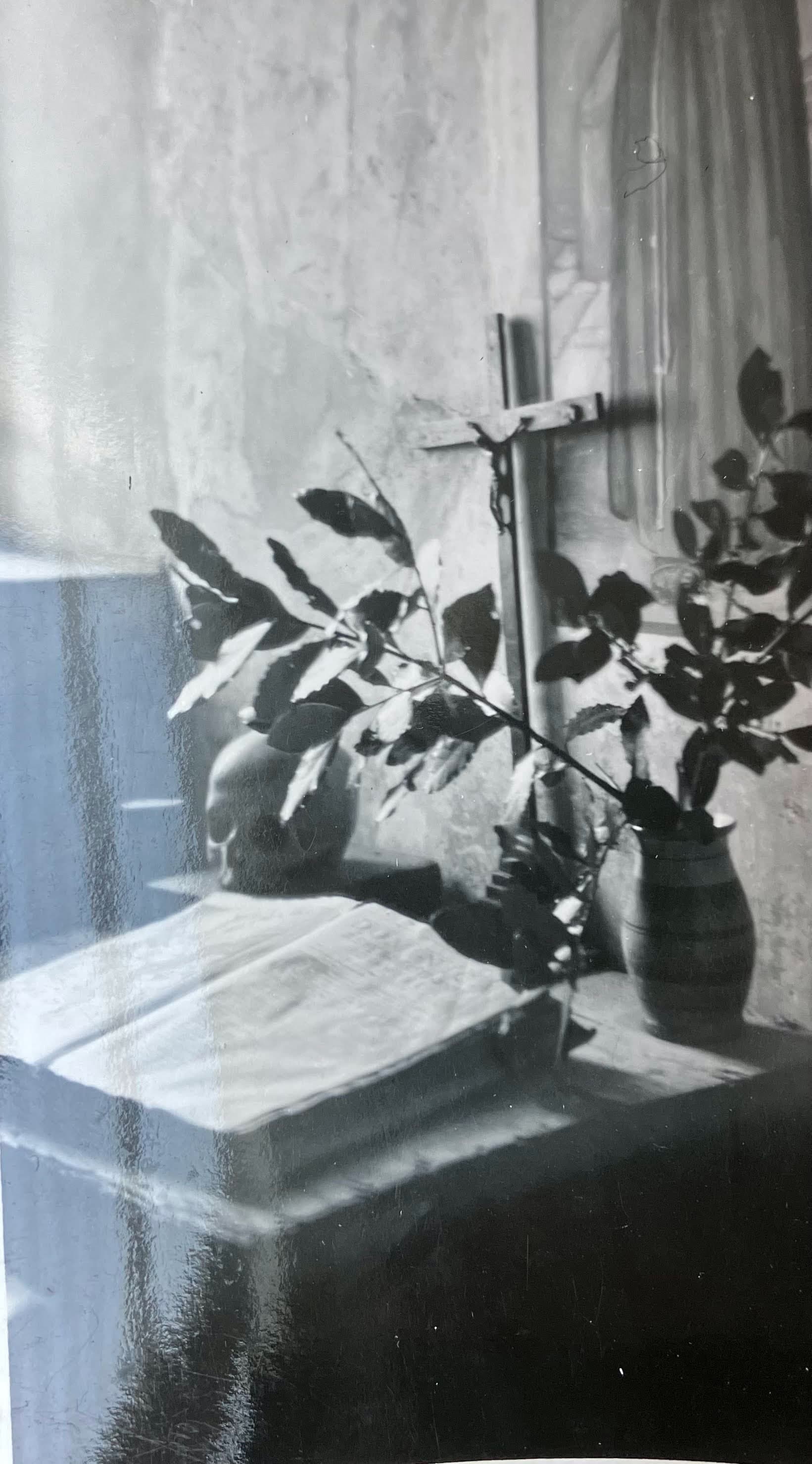 A pensive photo of a moment in a church with a cross, skull and prayer book open on display, taken in southern Italy, 1945.