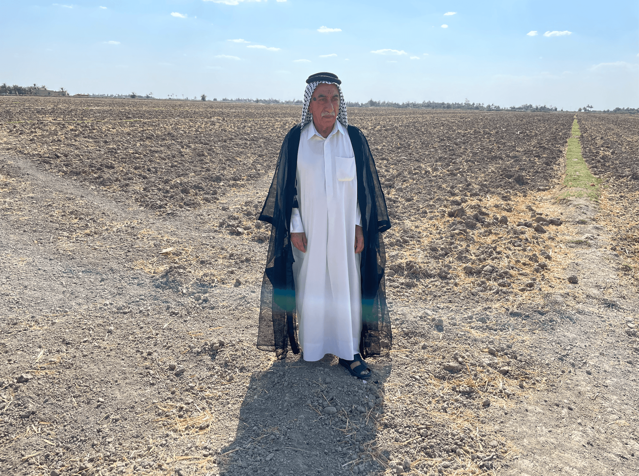 Salah Fareeq Al-Feroun standing on his farm that is now dry and barren, Al-Meshkhab, Iraq, Aug. 30, 2023.