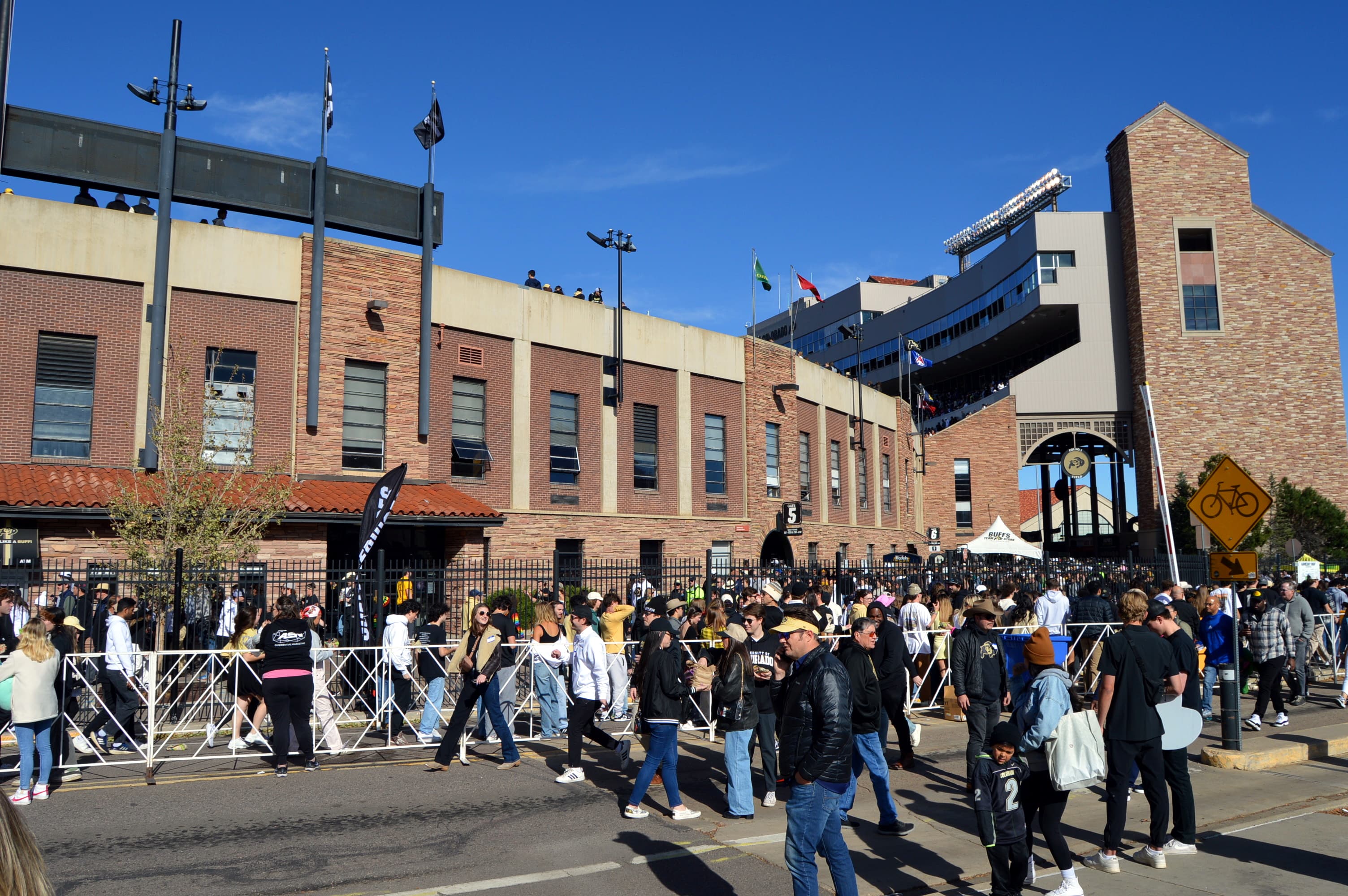 A crowd of people lined up outside of a football stadium