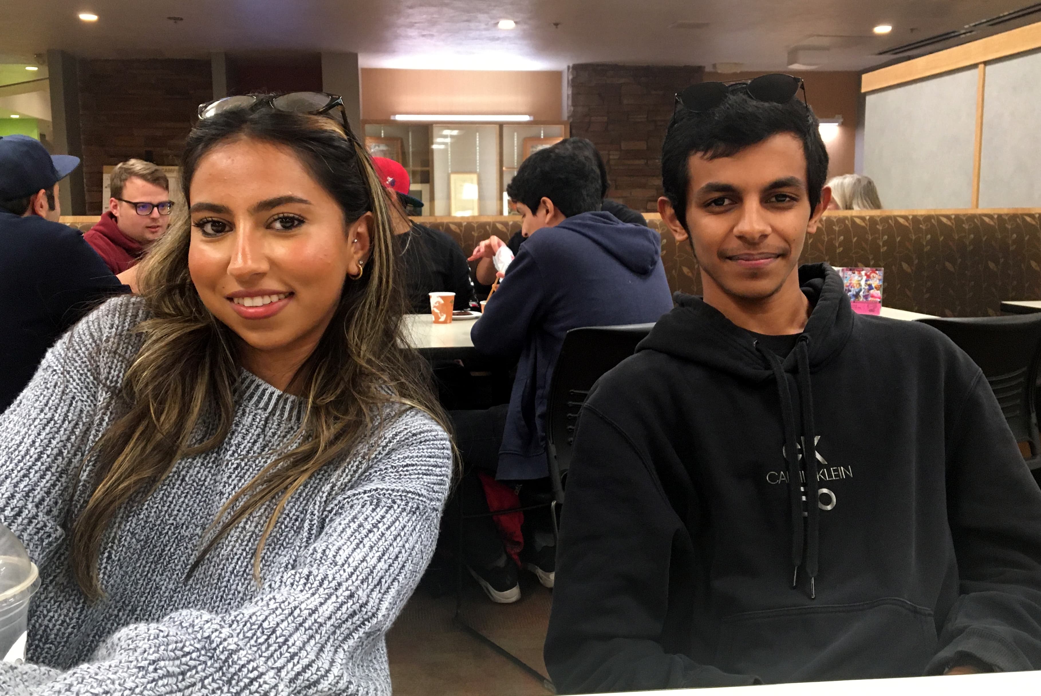 A female (left) and male (right) college students posing for a portrait