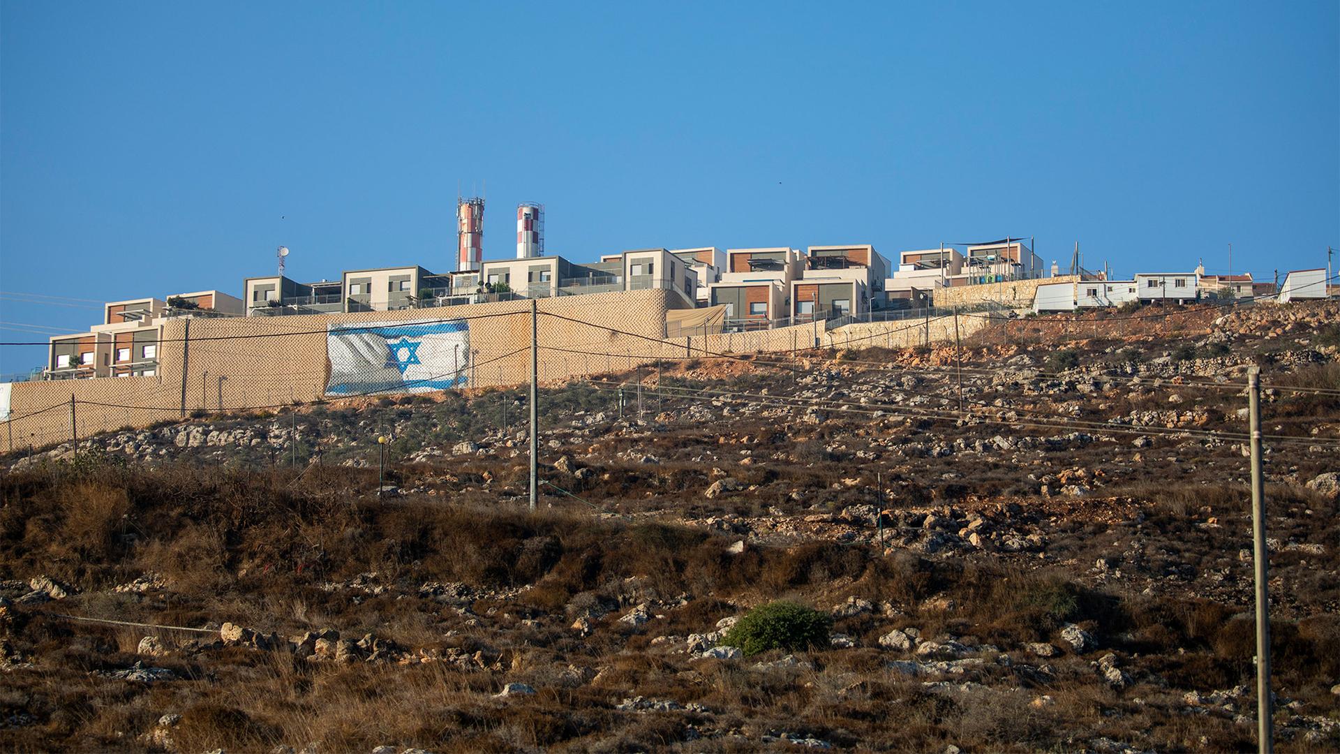 An Israeli flag on the surrounding wall of the West Bank Jewish settlement of Migdalim near the Palestinian town of Nablus, Oct. 25, 2021.