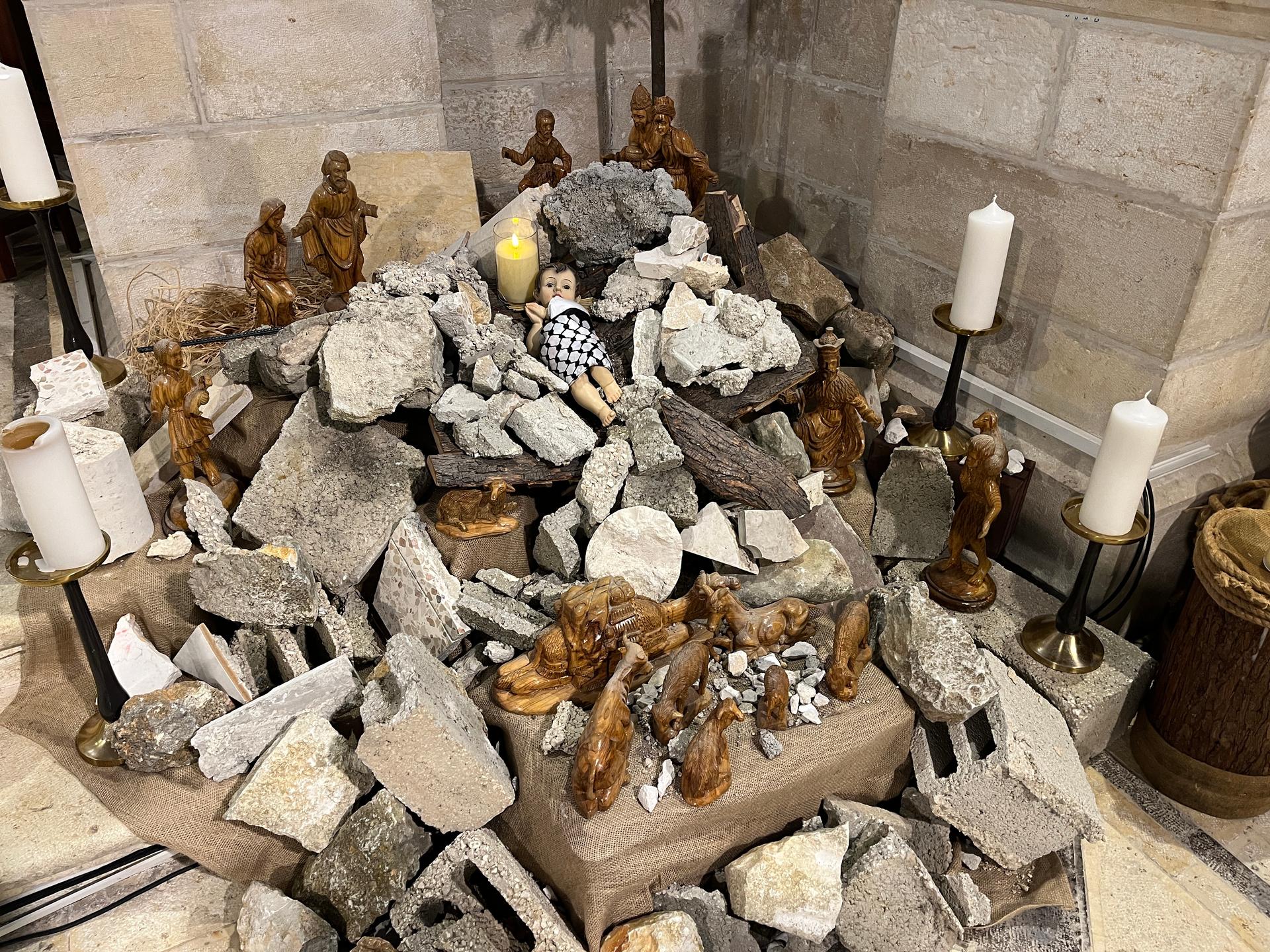 A rubble mound with a doll to be Jesus meant to reflect a broken nativity scene