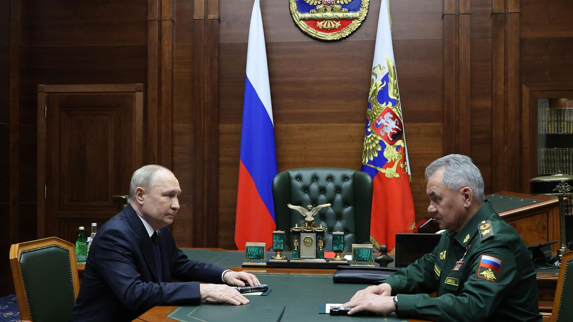 Russian President Vladimir Putin, left, listens to Russian Defense Minister Sergei Shoigu after their meeting with the top military brass in Moscow, Russia, Tuesday, Dec. 19, 2023.