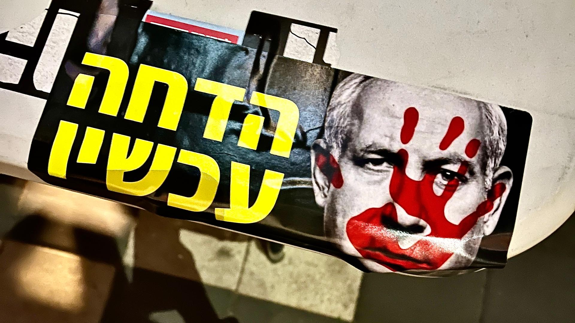 A sticker reads “Impeachment Now!” with a photo of Israeli President Benjamin Netanyahu with a bloody hand on his face