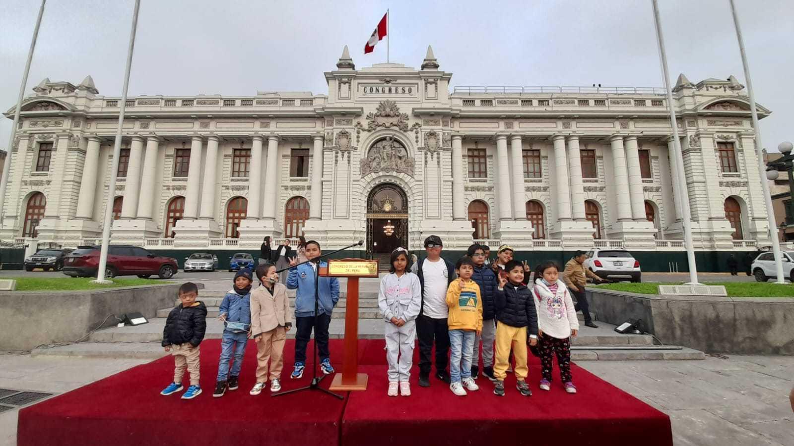 Children stand in front of the building of the Peruvian Congress as part of a call to demand accountability for cancer patients in Peru, September 2023.