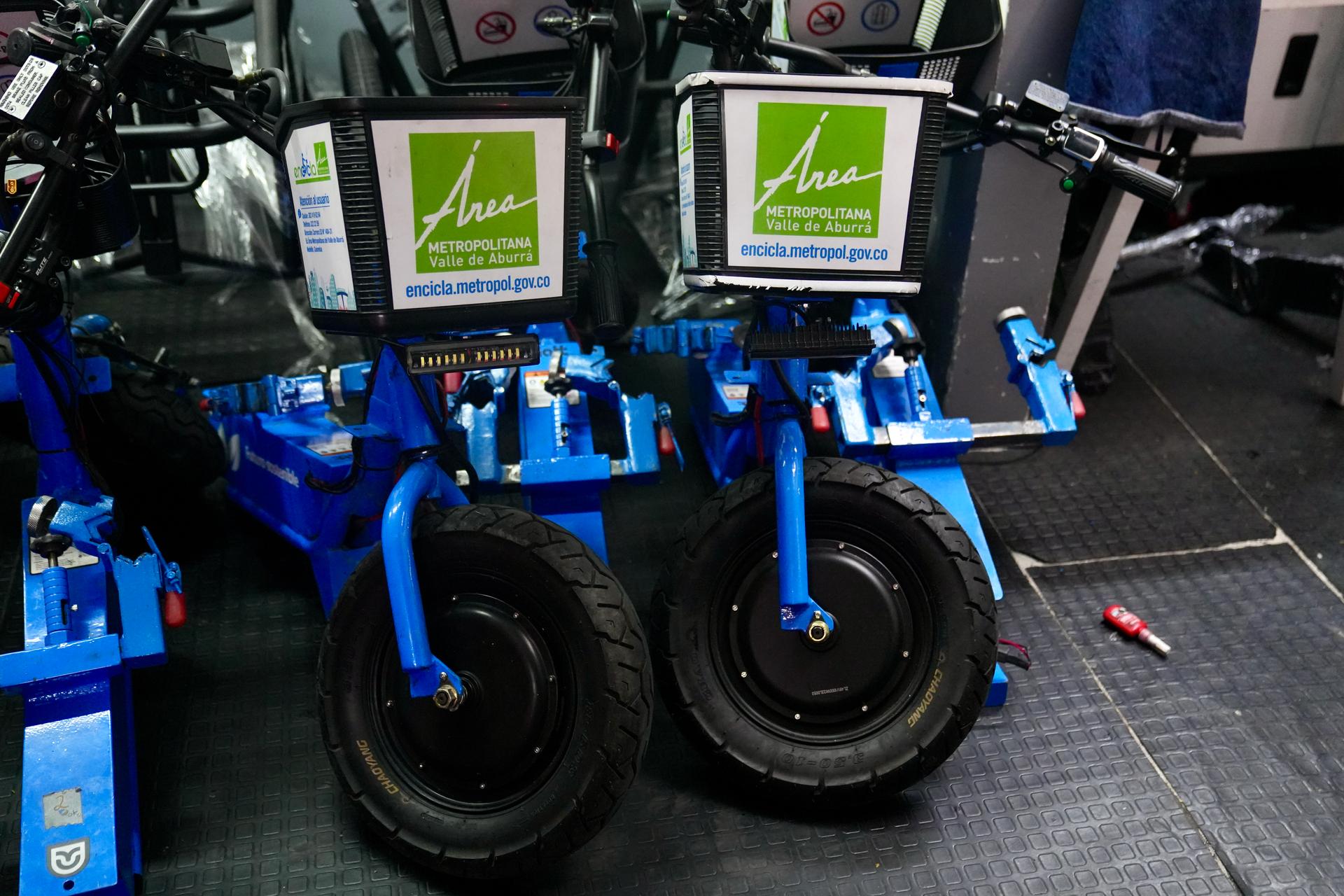 A photo of two blue electric bikes that have a green sign placed on front.
