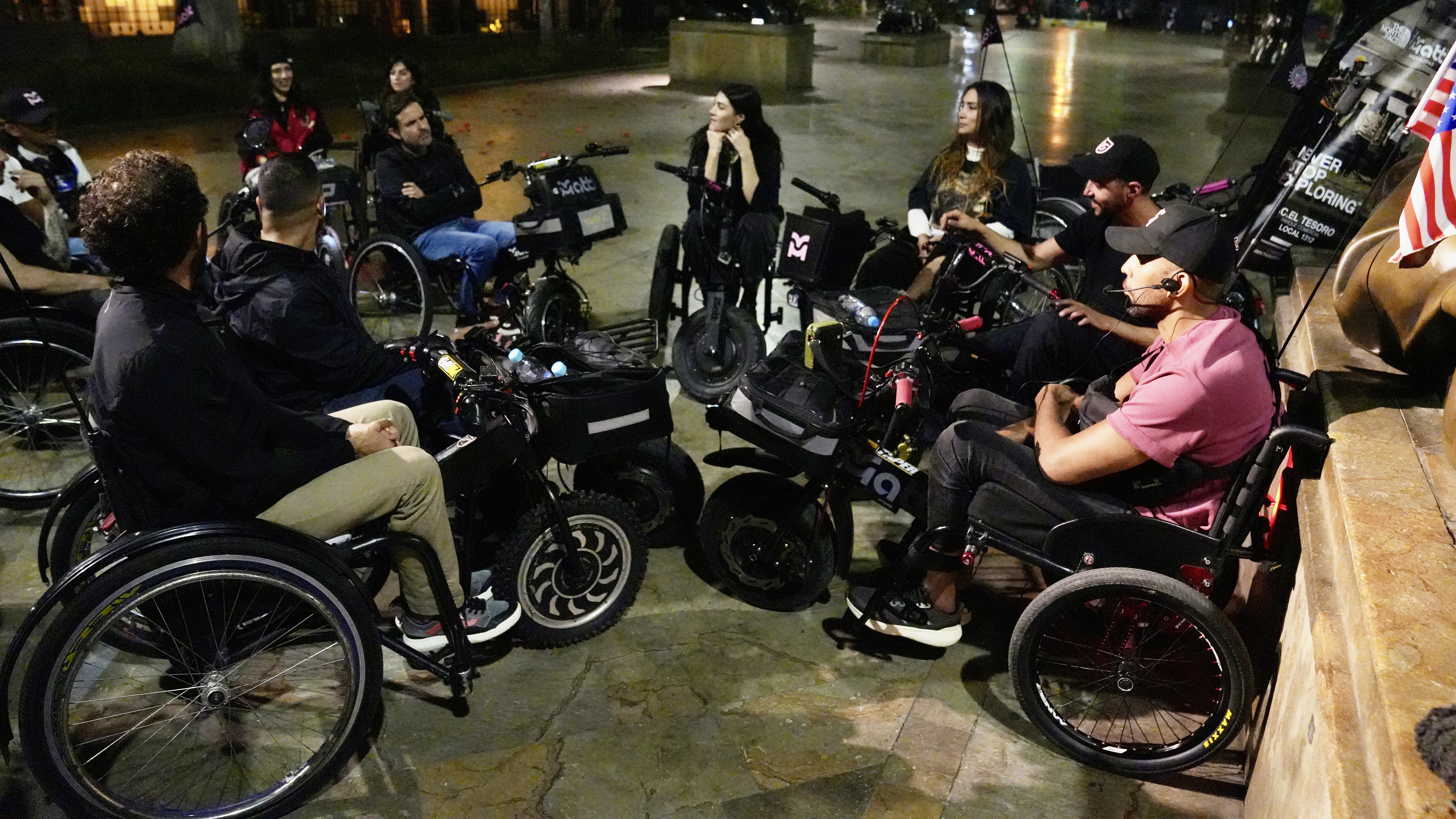Group of people at night sitting on motorized wheelchairs