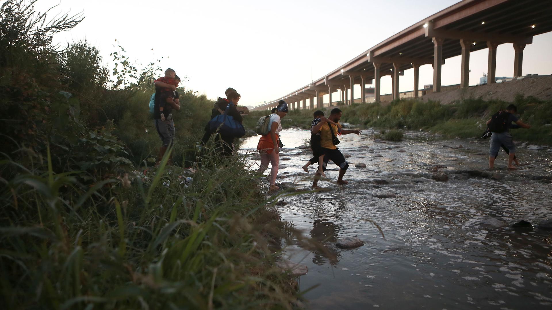 Venezuelan migrants walk across the Rio Bravo towards the United States border to surrender to the border patrol, from Ciudad Juarez, Mexico, Oct. 13, 2022.