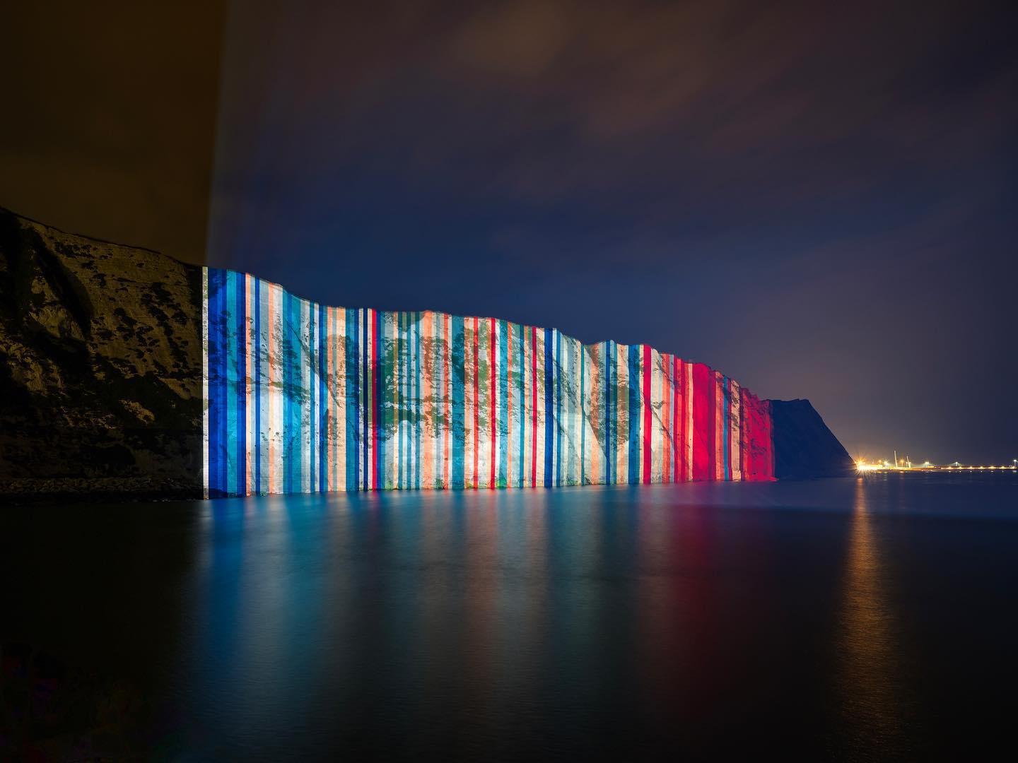 Projected blue and red stripes over white cliffs