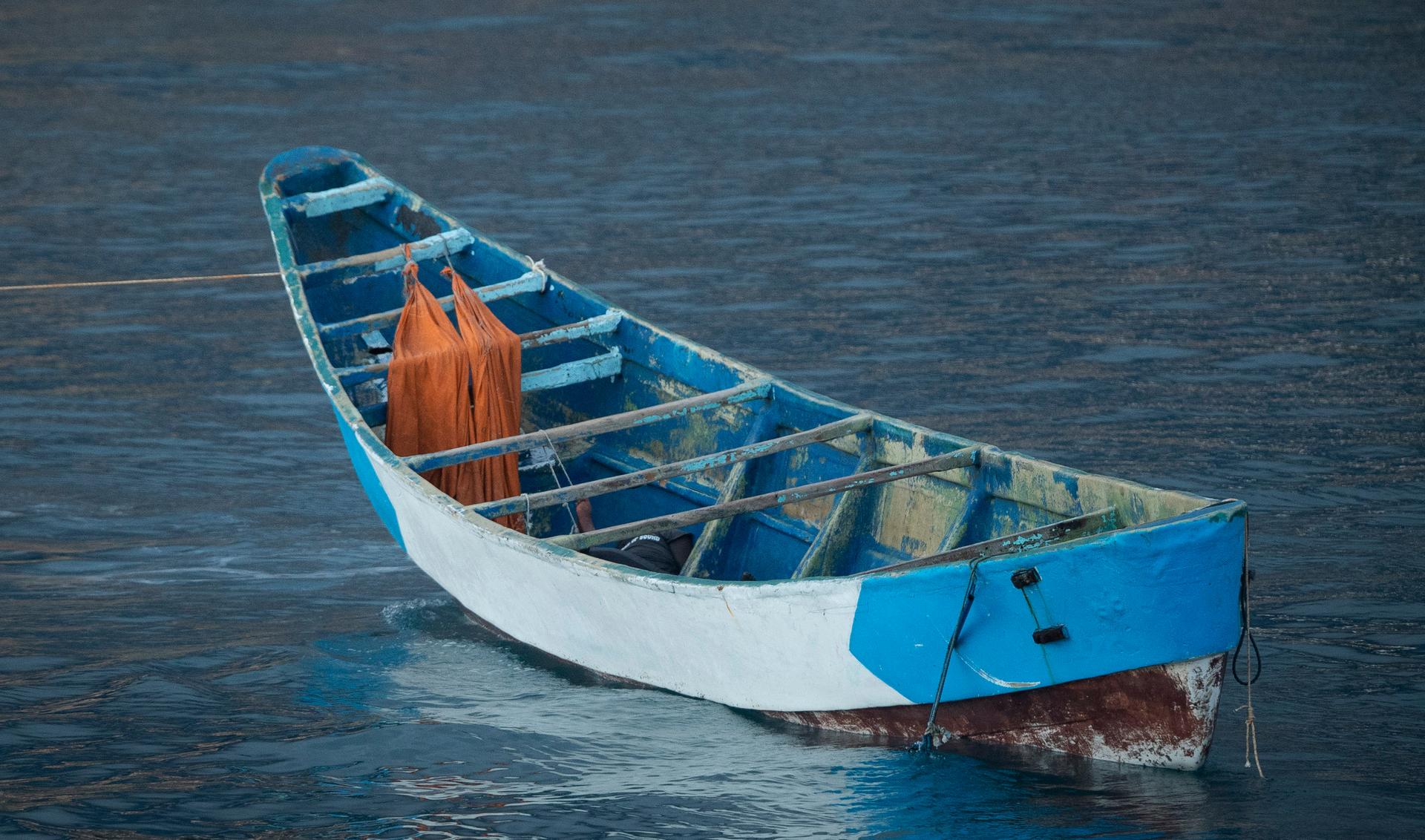 Empty blue boat in ocean