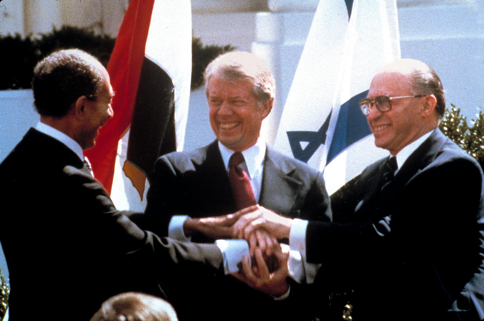 Egyptian President Anwar Sadat, left, US President Jimmy Carter, center, and Israeli Prime Minister Menachem Begin clasp hands at the White House as they completed signing of the peace treaty between Egypt and Israel in Washington on March, 26, 1979. 