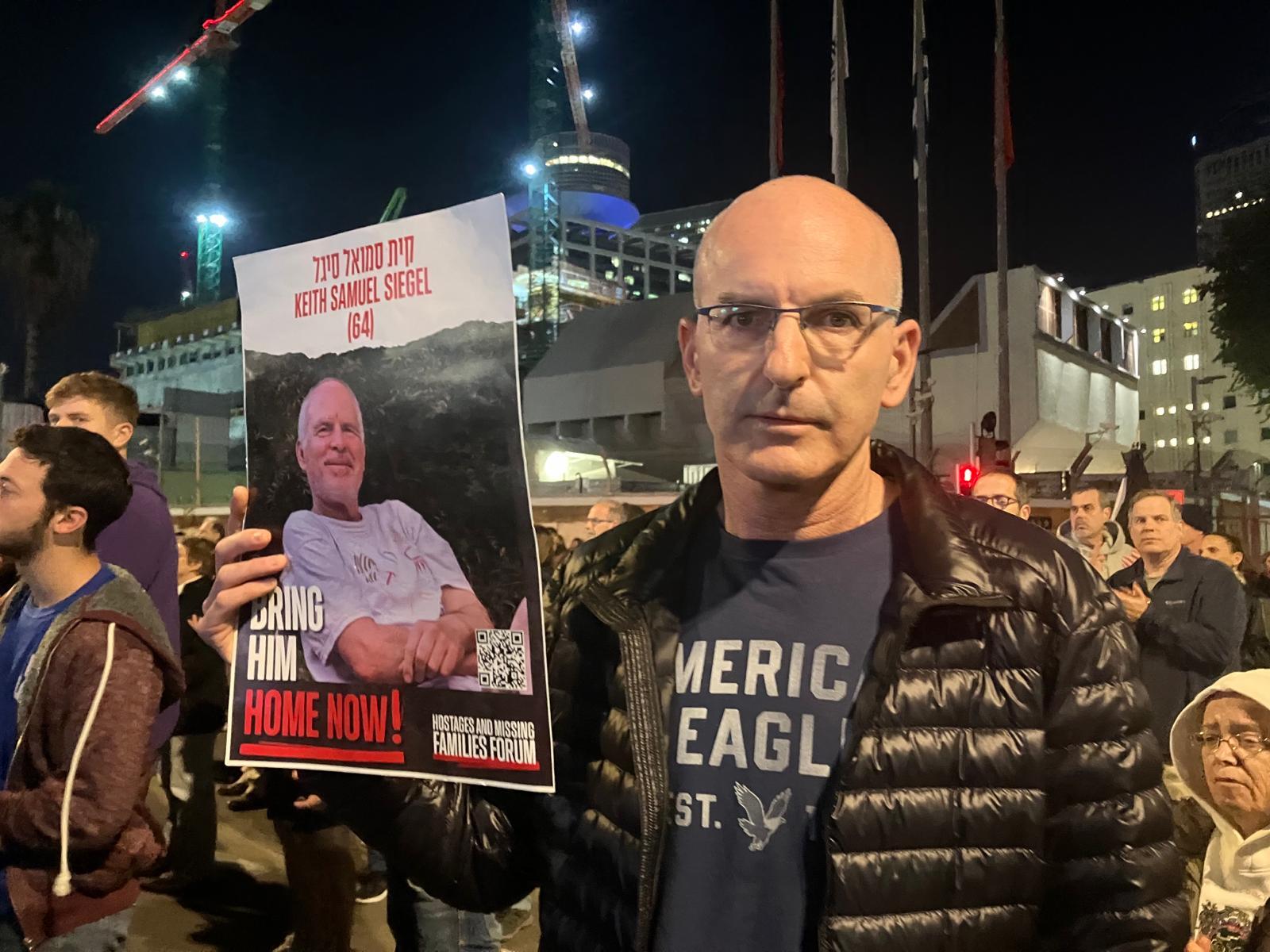 Ari Treiwif holds a sign in Tel Aviv for his longtime friend Keith Siegel who was abducted from Kibbutz Kfar Aza on Oct. 7.