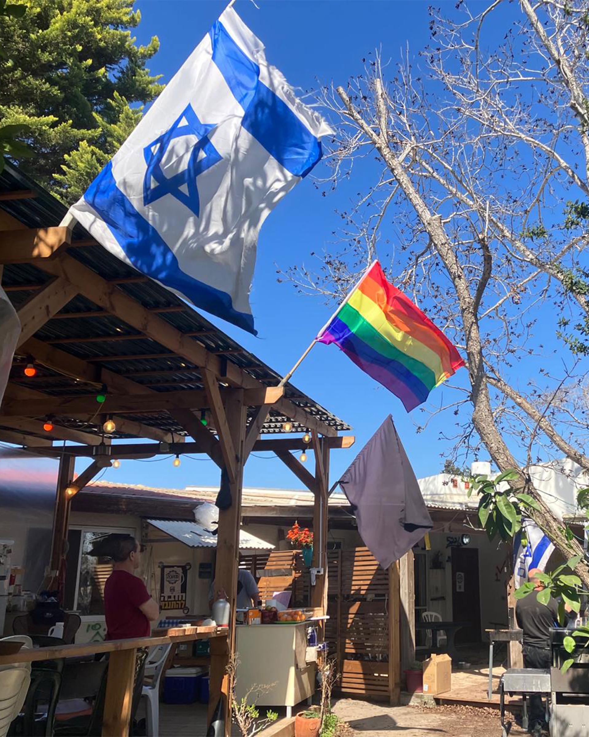 Three flags hang outside the Cohen-Shnurman home; the Israeli flag, the rainbow flag and, most recently, a black mourning flag put up in early December to honor the hostages taken in to Gaza.