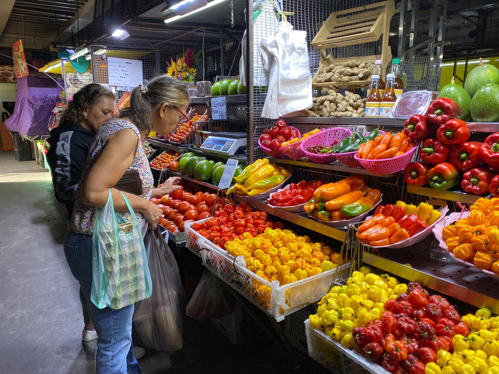 At a market in Caracas people buy vegetables and fruits that can be paid for in US dollars.