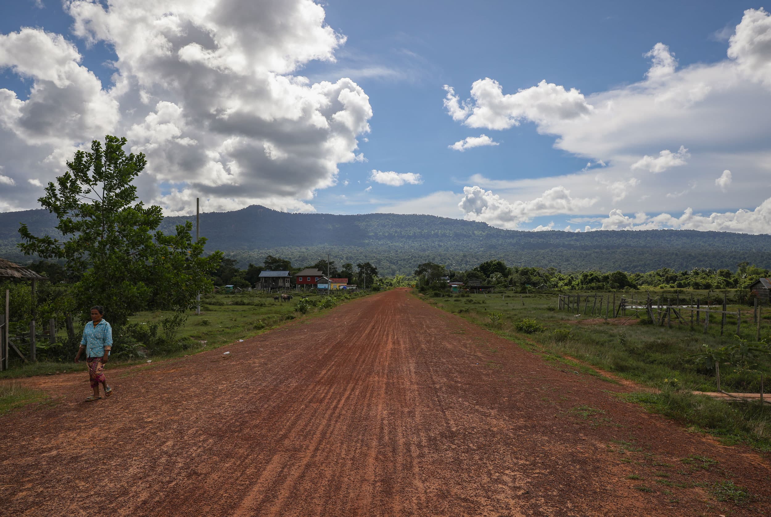 A local resident walks down the red road to Chamnar Village in the Areng Valley of the Southern Cardamom National Park.