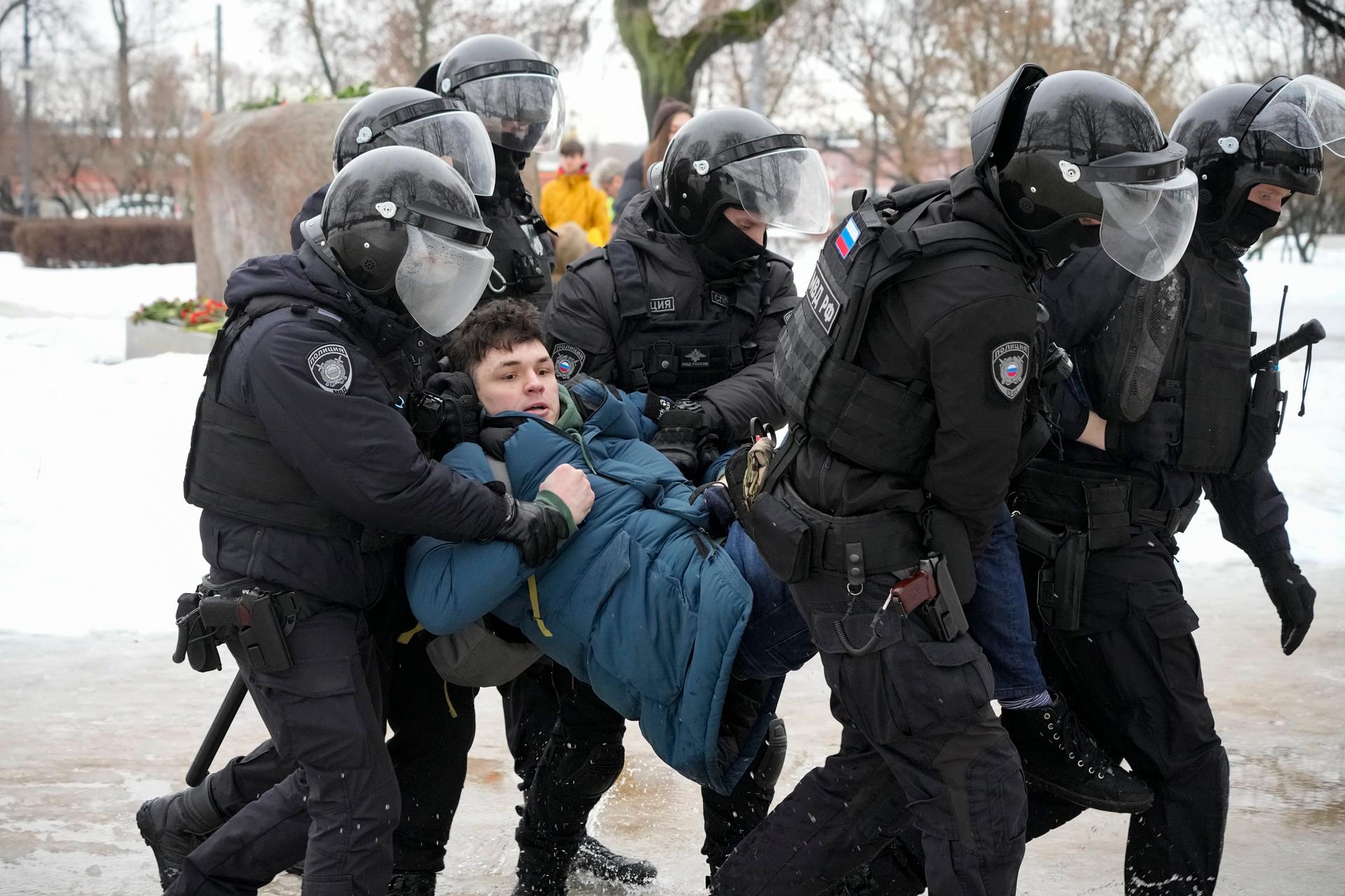 Police detain a man trying to lay flowers to honor Alexei Navalny at a monument in St. Petersburg, Russia, to victims of Soviet repression, on Saturday, Feb. 17, 2024. 