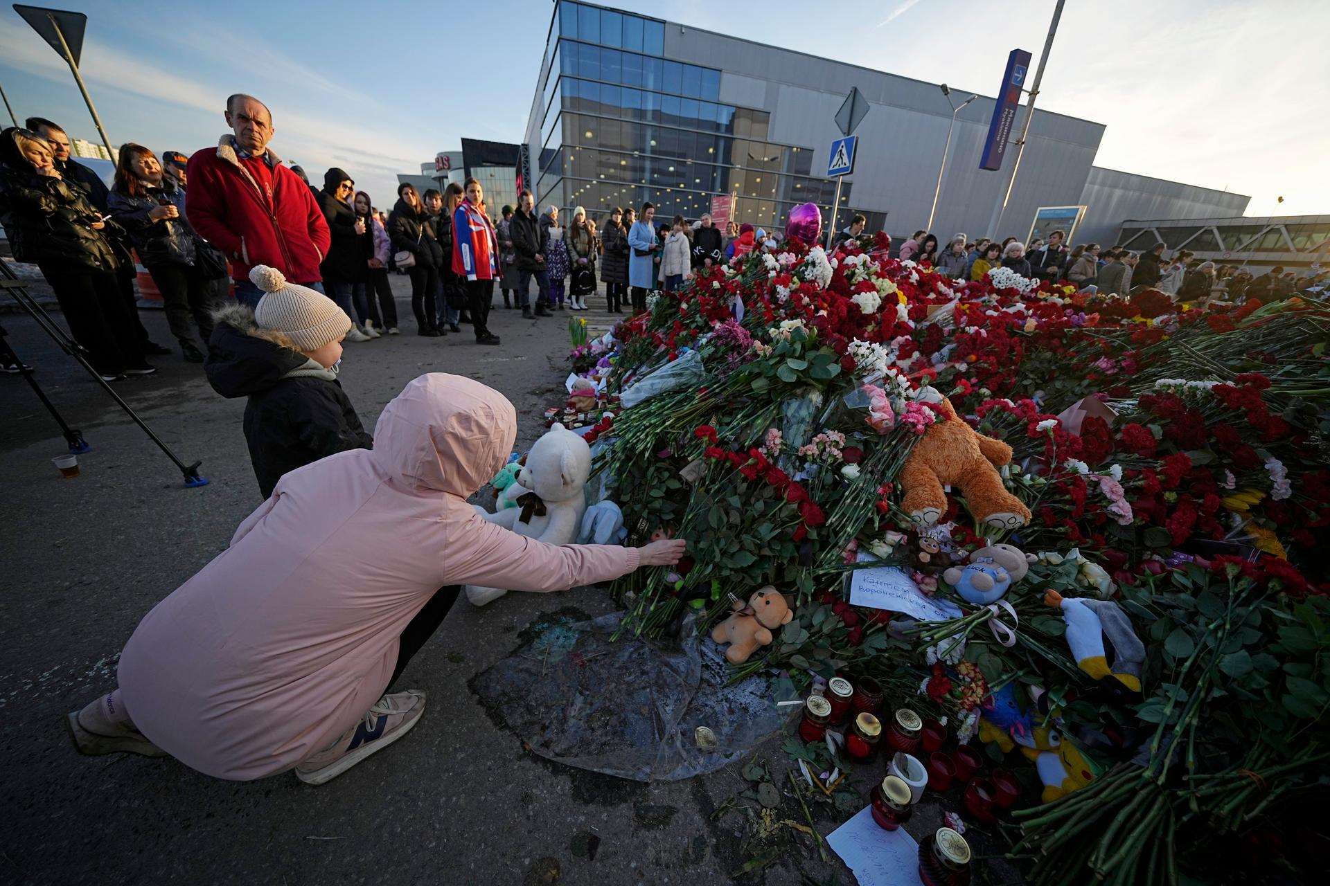 People lay flowers at a makeshift memorial in front of the Crocus City Hall on the western outskirts of Moscow, Russia, Monday, March 25, 2024.