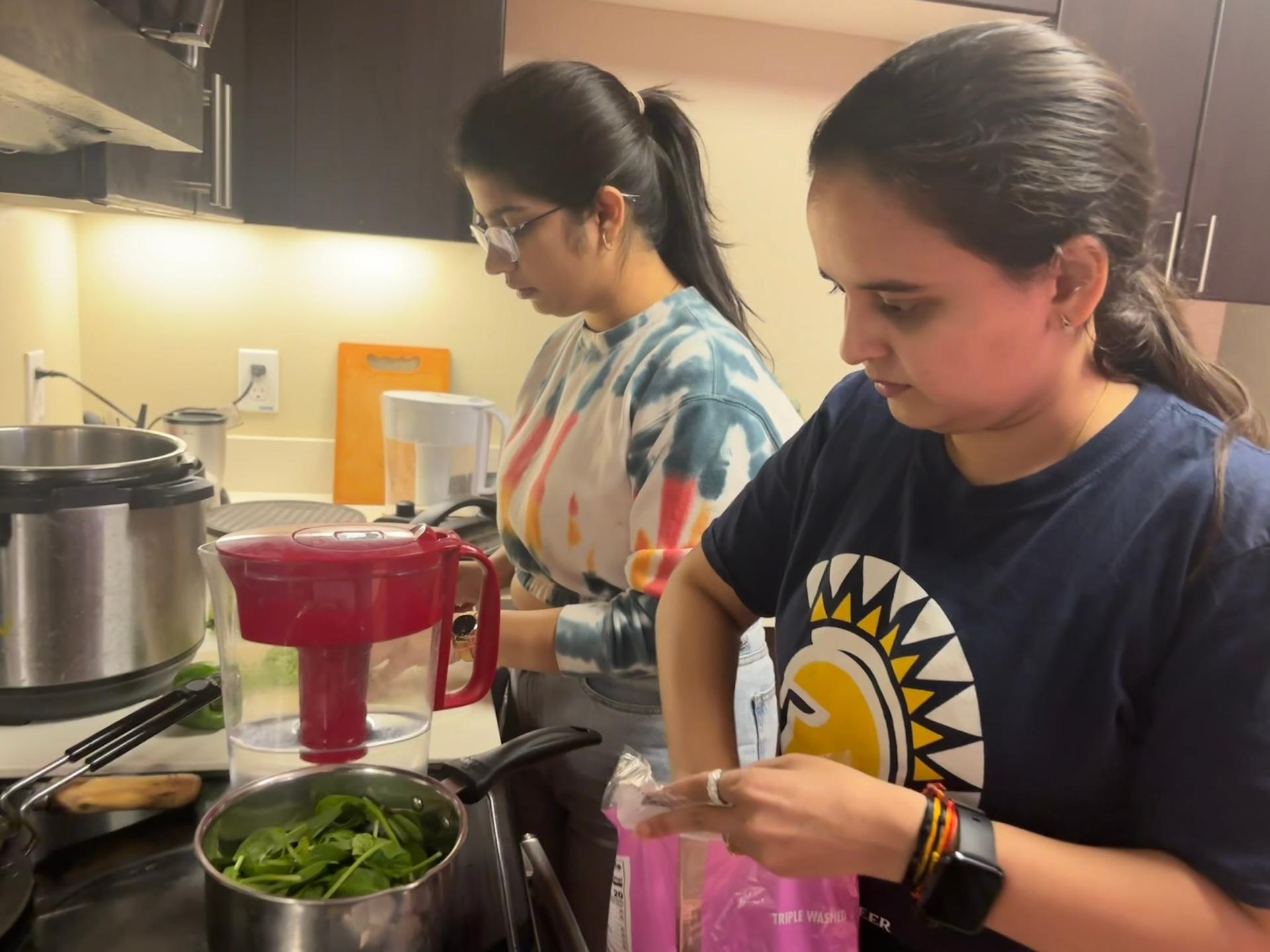 two female students cooking in the kitchen