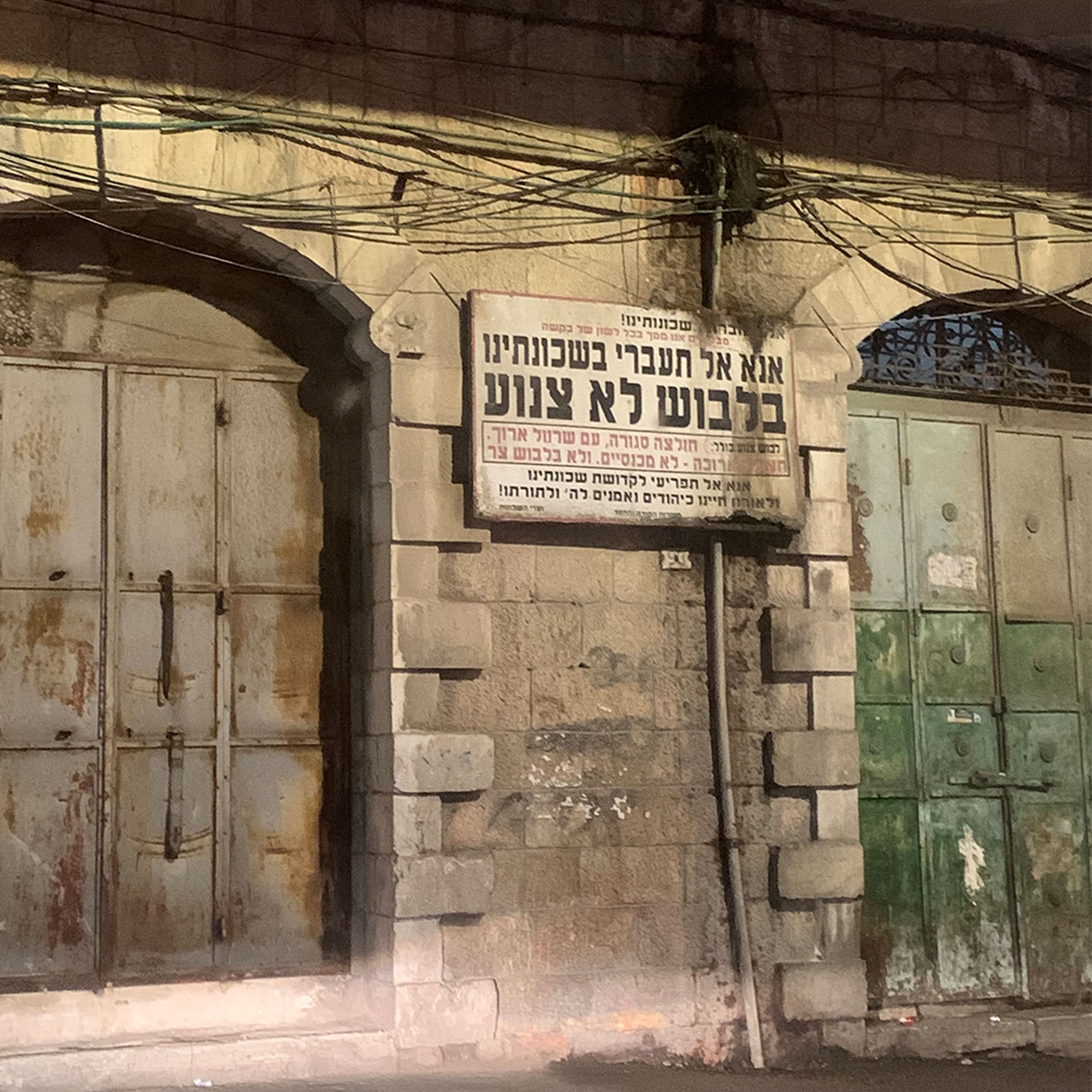 A sign asking women to dress modestly when passing through Mea She'arim, and giving examples of what does and does not constitute modest dress.