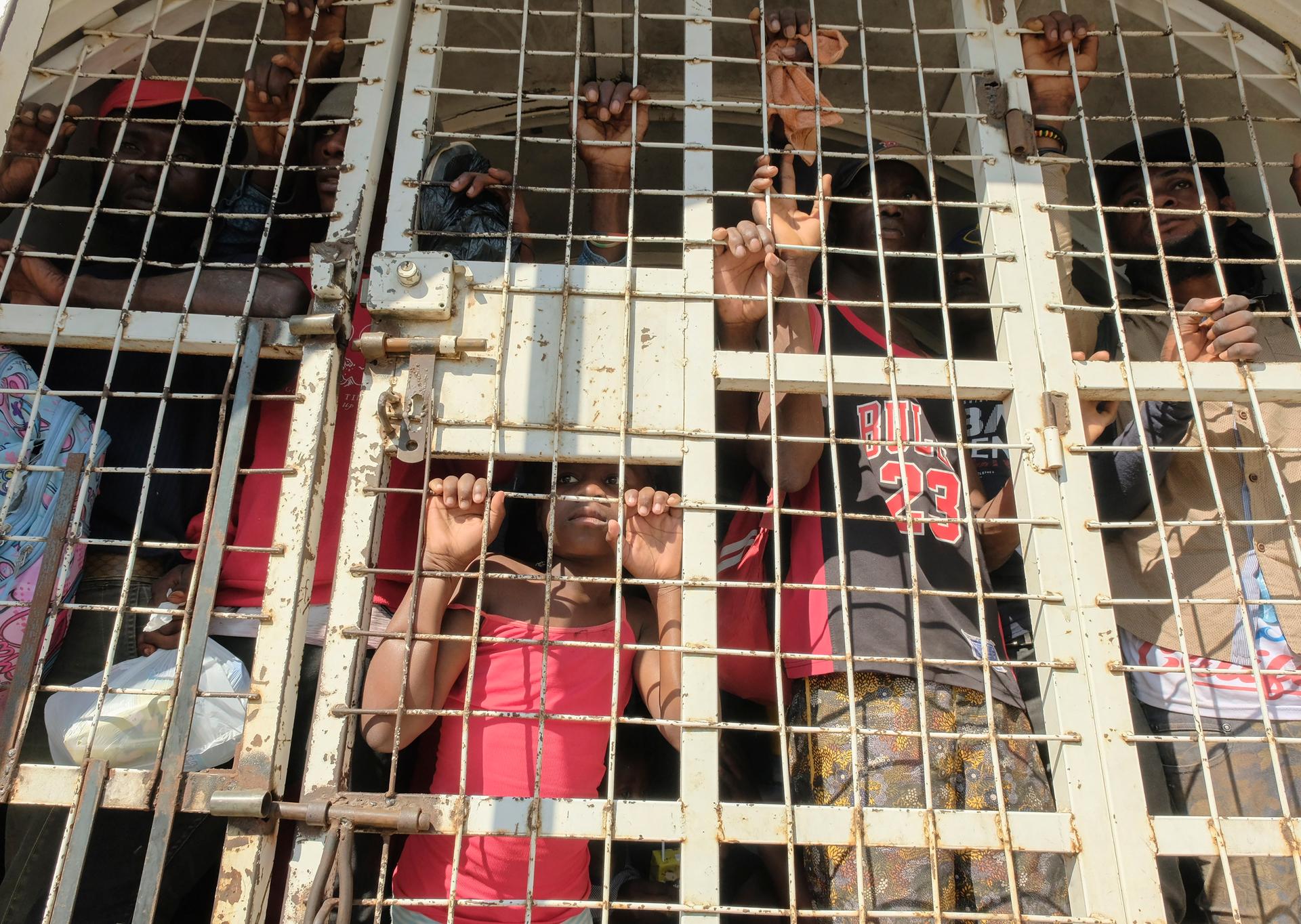 People who were detained for deportation to Haiti stand inside a police truck on the border bridge that connects Dajabon, Dominican Republic with Haiti, March 18, 2024.