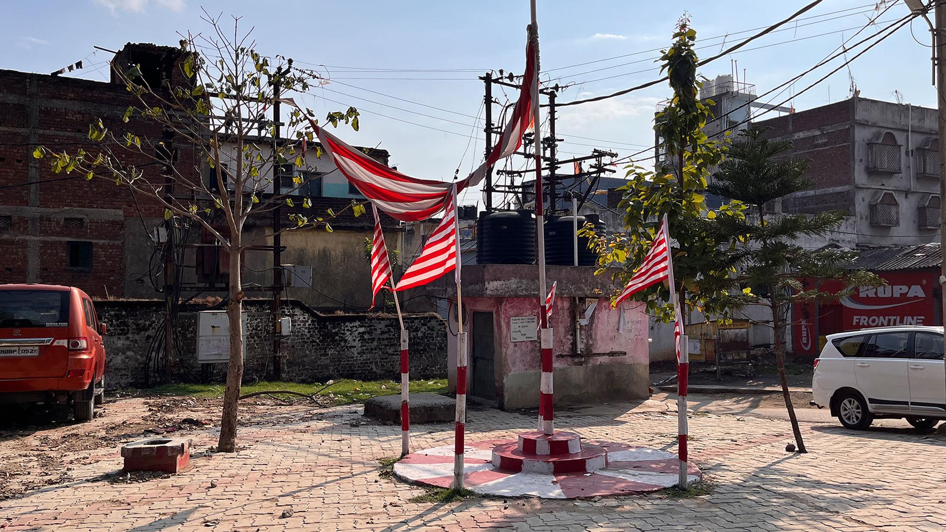 Striped red-and-white flags adorn a sacred grove in a quiet neighborhood in Ranchi in India. The ubiquitous flags are an assertion of tribal identity.