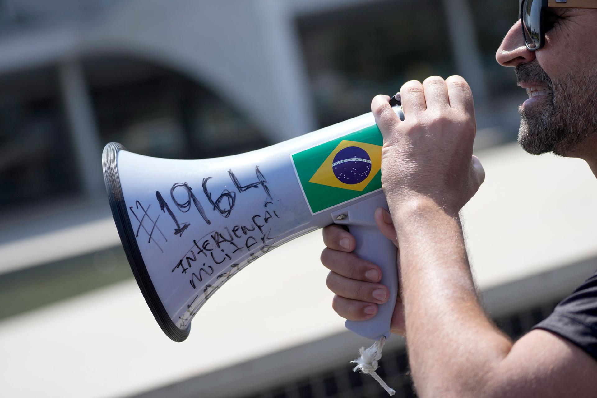 Supporter of Brazil's President Jair Bolsonaro, Dom Verneck, leader of the interventionist movement, uses a megaphone marked in Portuguese; 
