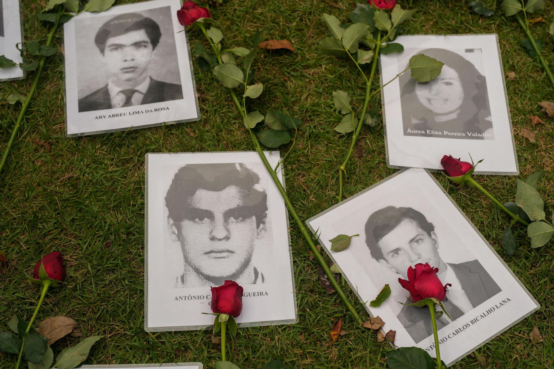 Photos of persons who were killed during Brazil's past dictatorship are placed on the ground during the 