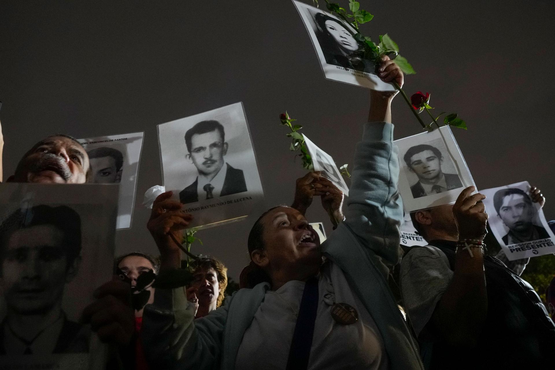 Demonstrators hold photos of persons who were killed during Brazil's past dictatorship during the 