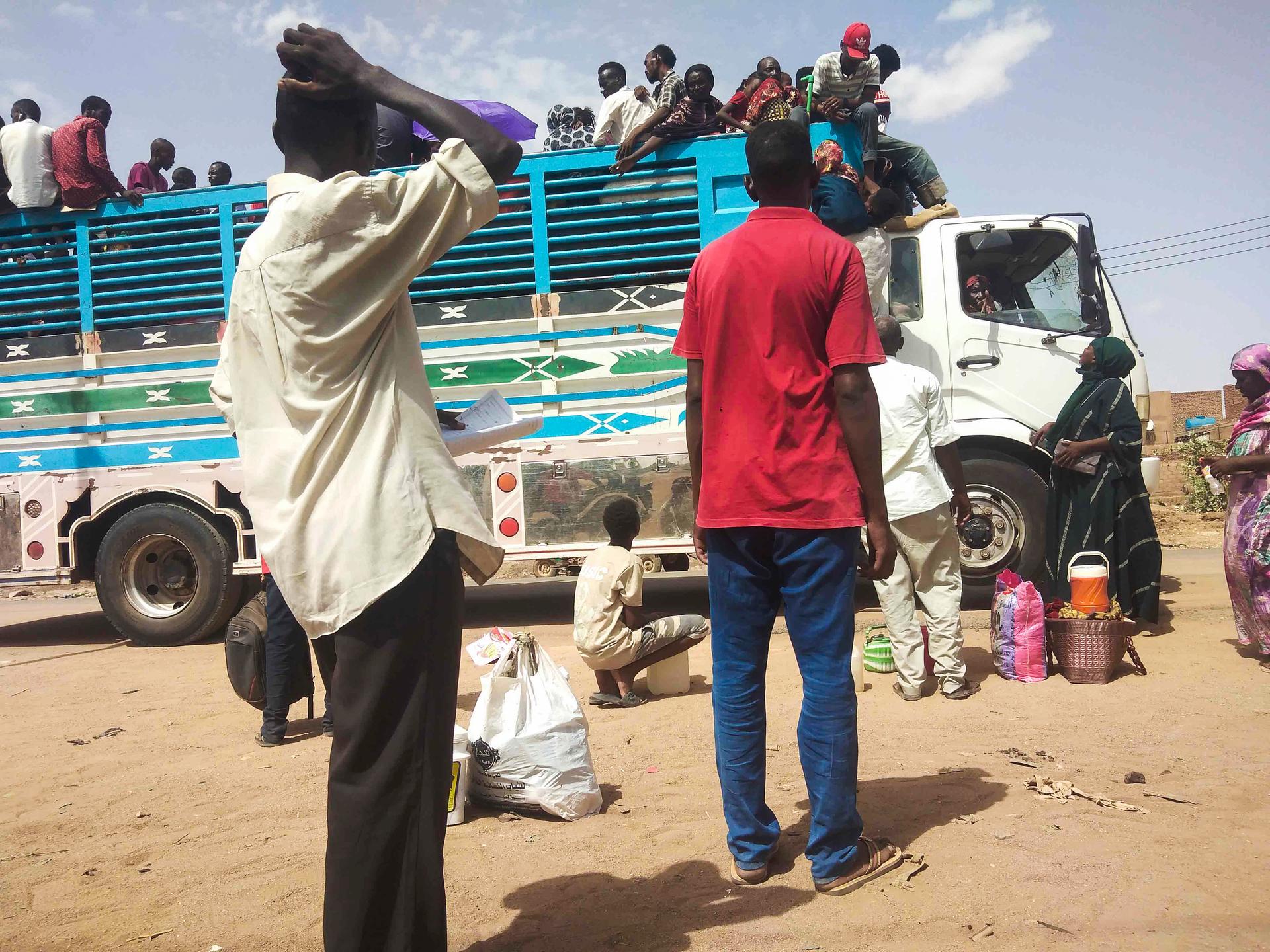 People board a truck as they leave Khartoum, Sudan, Monday, June 19, 2023. 