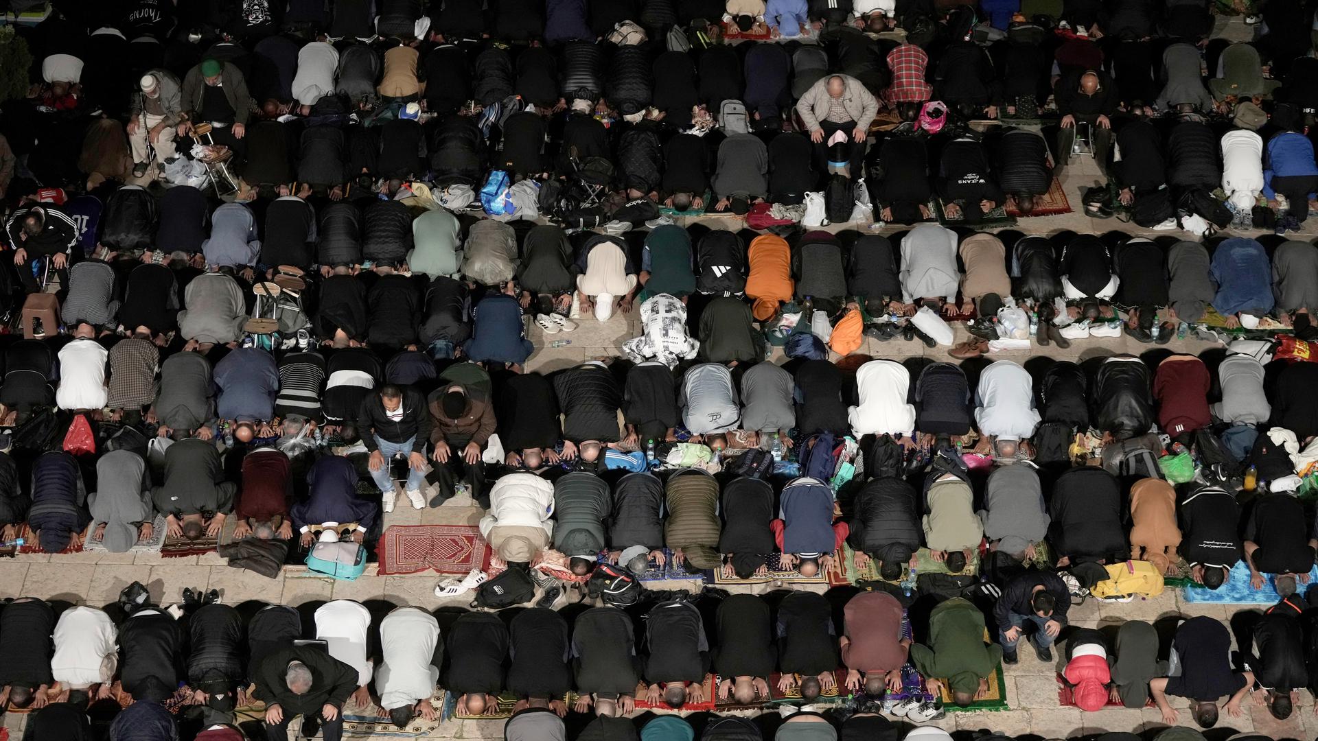 Rows of people kneeling in prayer
