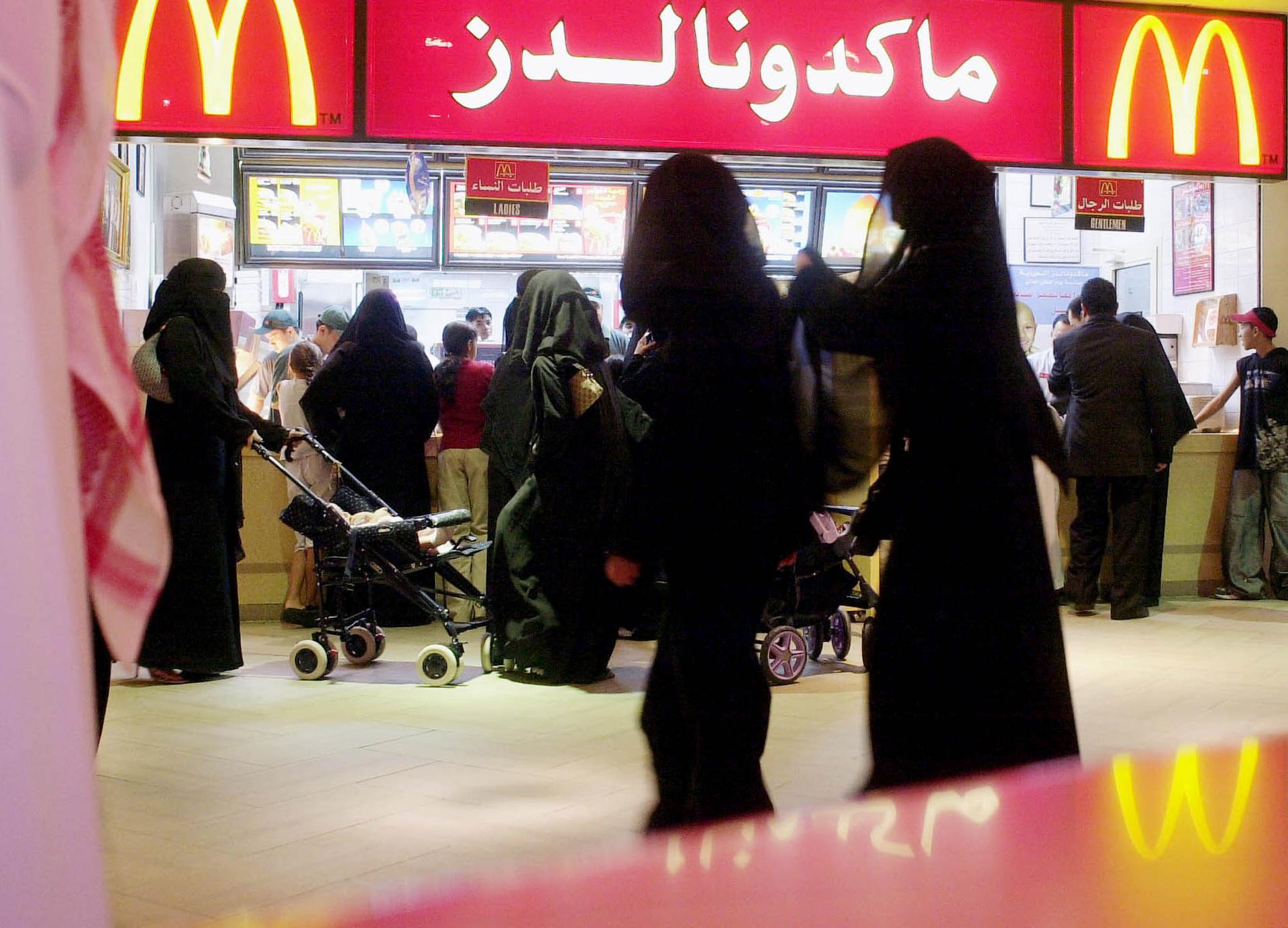 Saudis gather by a McDonald's fast food restaurant in a Riyadh, Saudi Arabia, shopping mall, Oct. 31, 2003.