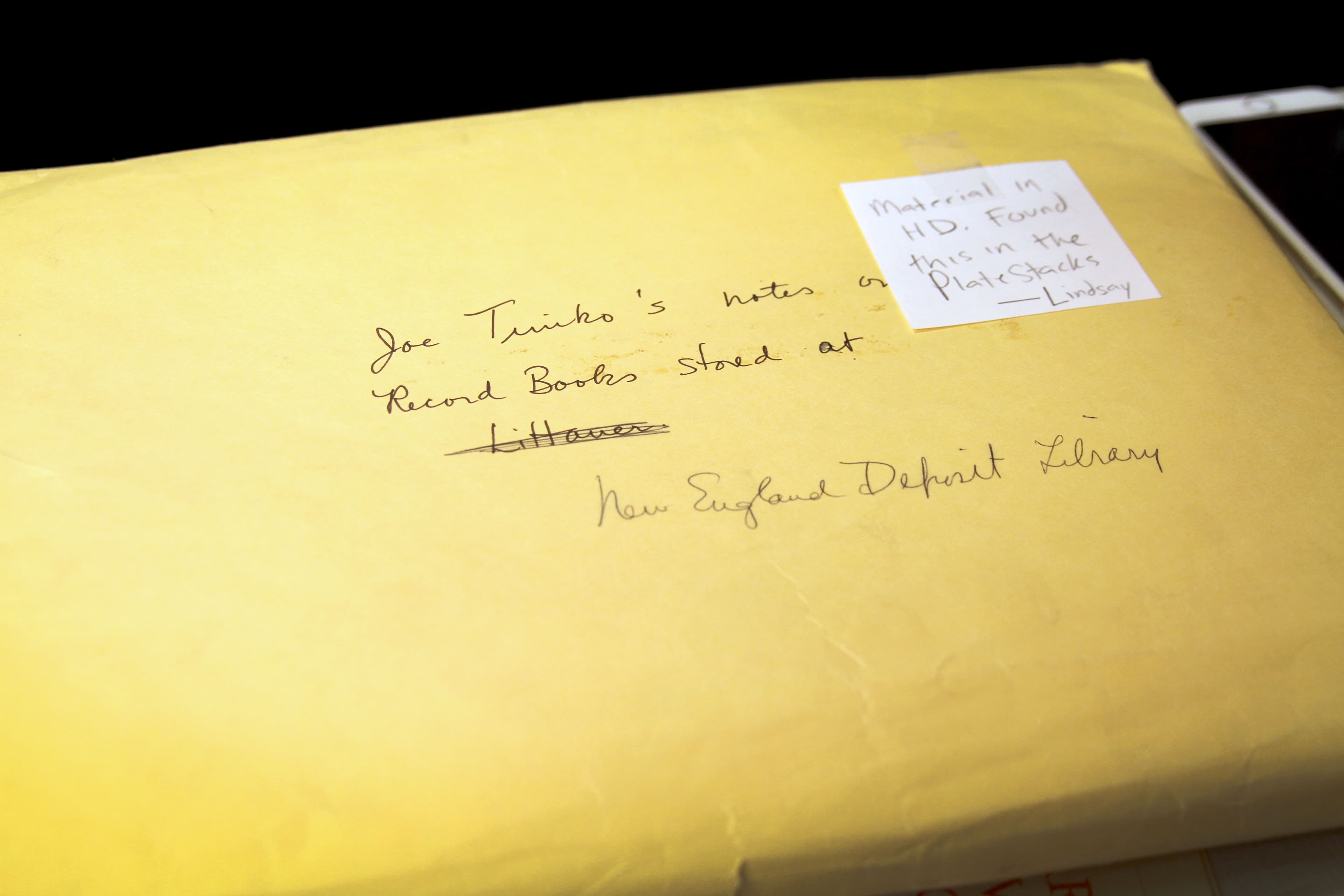 A yellow manila envelope has a Post-it it that says