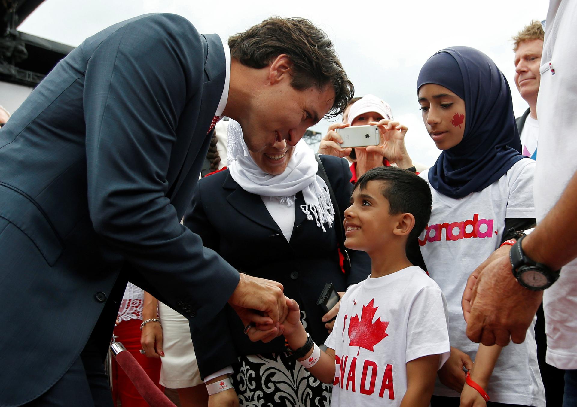 Canada's Prime Minister Justin Trudeau shakes hands with a Syrian refugee during Canada Day celebrations on Parliament Hill in Ottawa, Ontario, Canada, July 1, 2016.