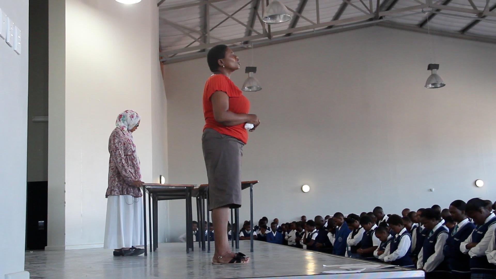 Mrs. Booi, a Xhosa teacher at COSAT, leads the school in prayer.
