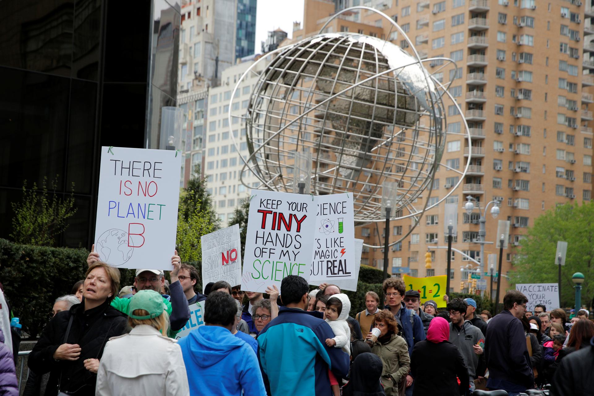 People walk past Trump International Hotel and Tower during the Earth Day 'March For Science NYC' demonstration to coincide with similar marches globally in New York City, April 22, 2017.
