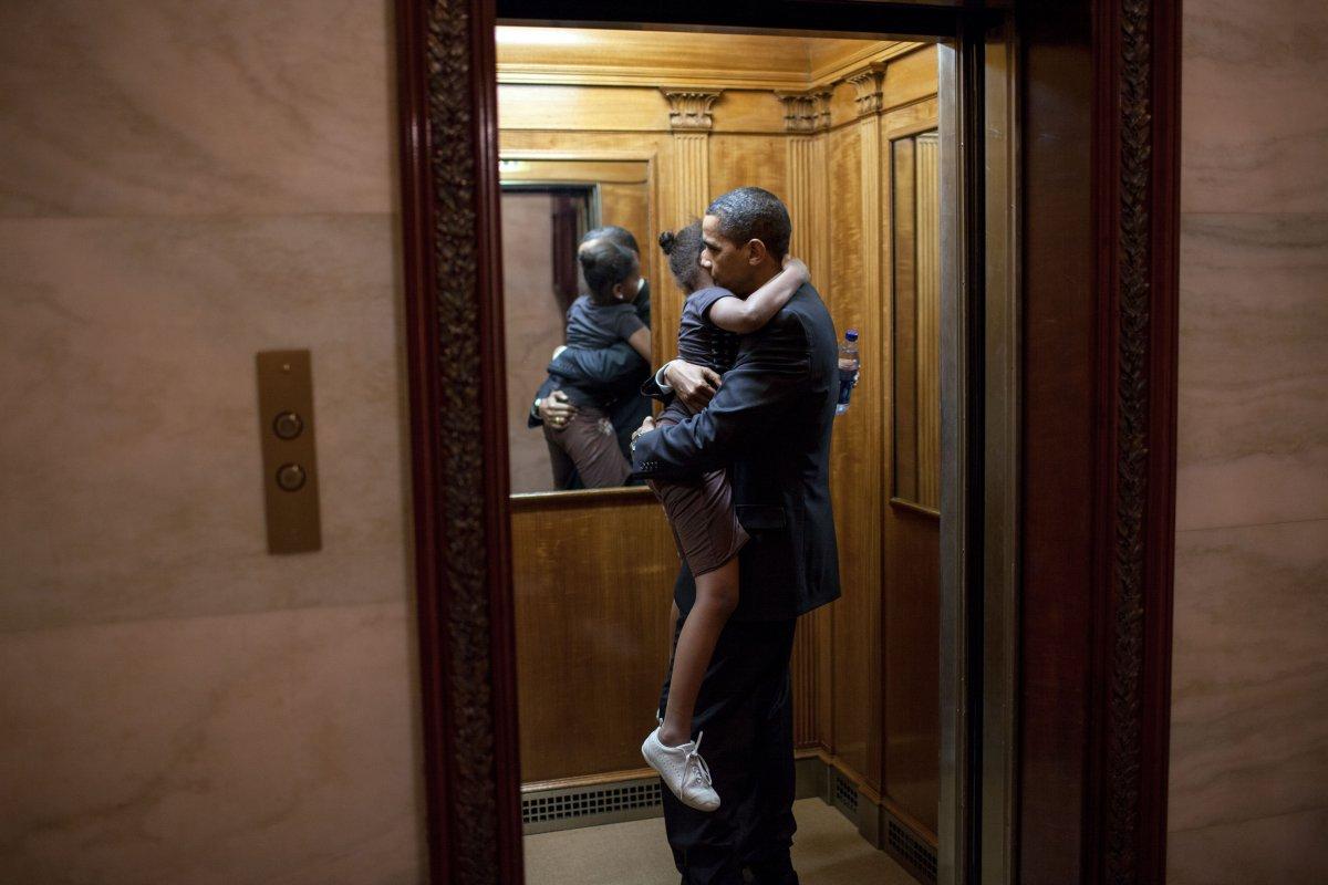The official photos of Barack Obama, pictured here with his daughter Sasha in the White House elevator in 2009, are often more tender.