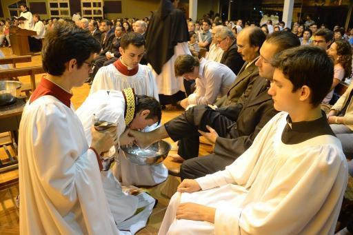 Father Carlos Urrutigoity kisses the foot of a congregant in Ciudad Del Este.